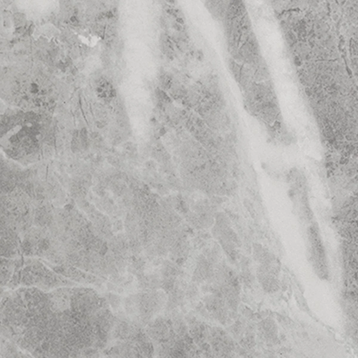 Close-up of a textured, gray and white surface with faded, indistinct markings.