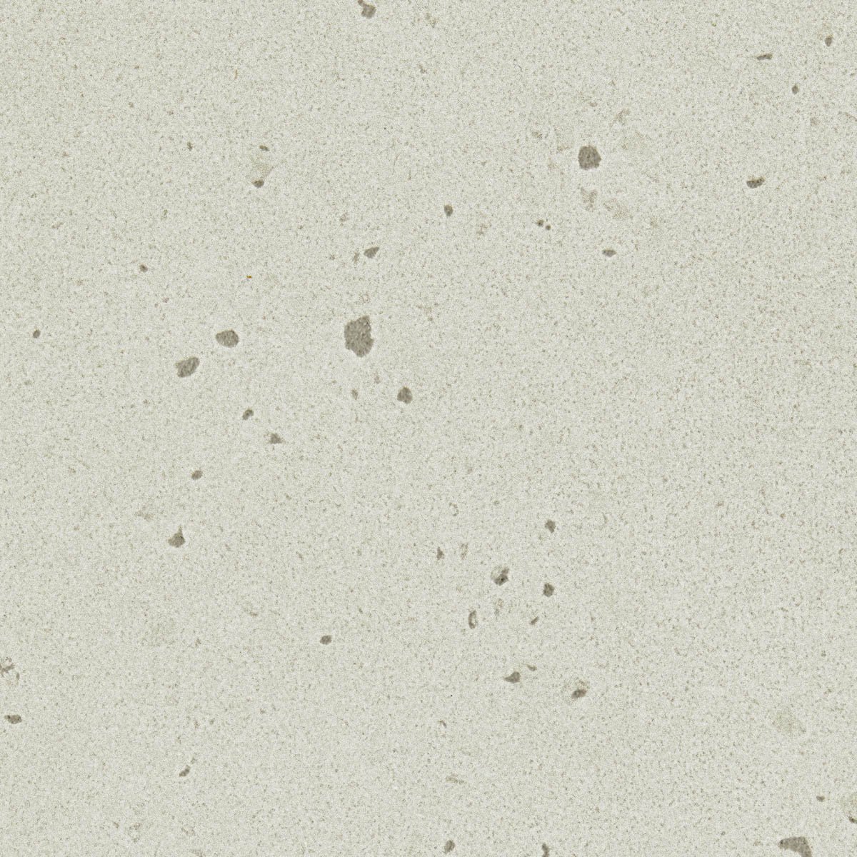 Close-up of a speckled beige surface, possibly a countertop or wall with small dark spots.