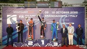 Podium at a race awards ceremony with winners and officials in front of a banner for F1 and Mondokart.