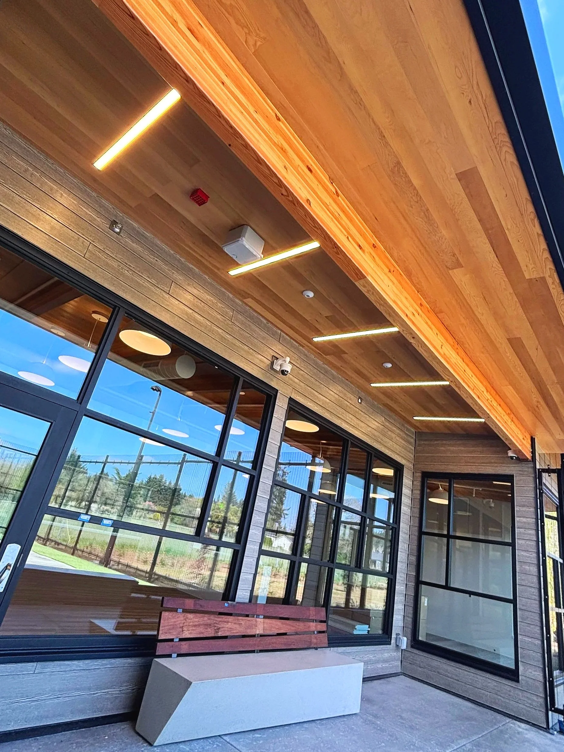 Exterior patio lighting installed in tongue-and-groove ceiling at healthcare facility