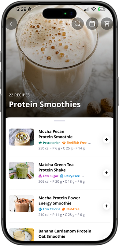 A glass of protein smoothie with frothy surface and bubbles, placed on a marble surface.