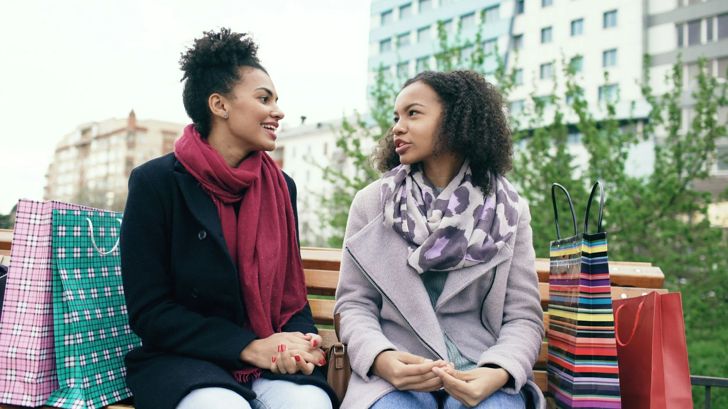 Two women talking outdoors, sharing a thoughtful conversation