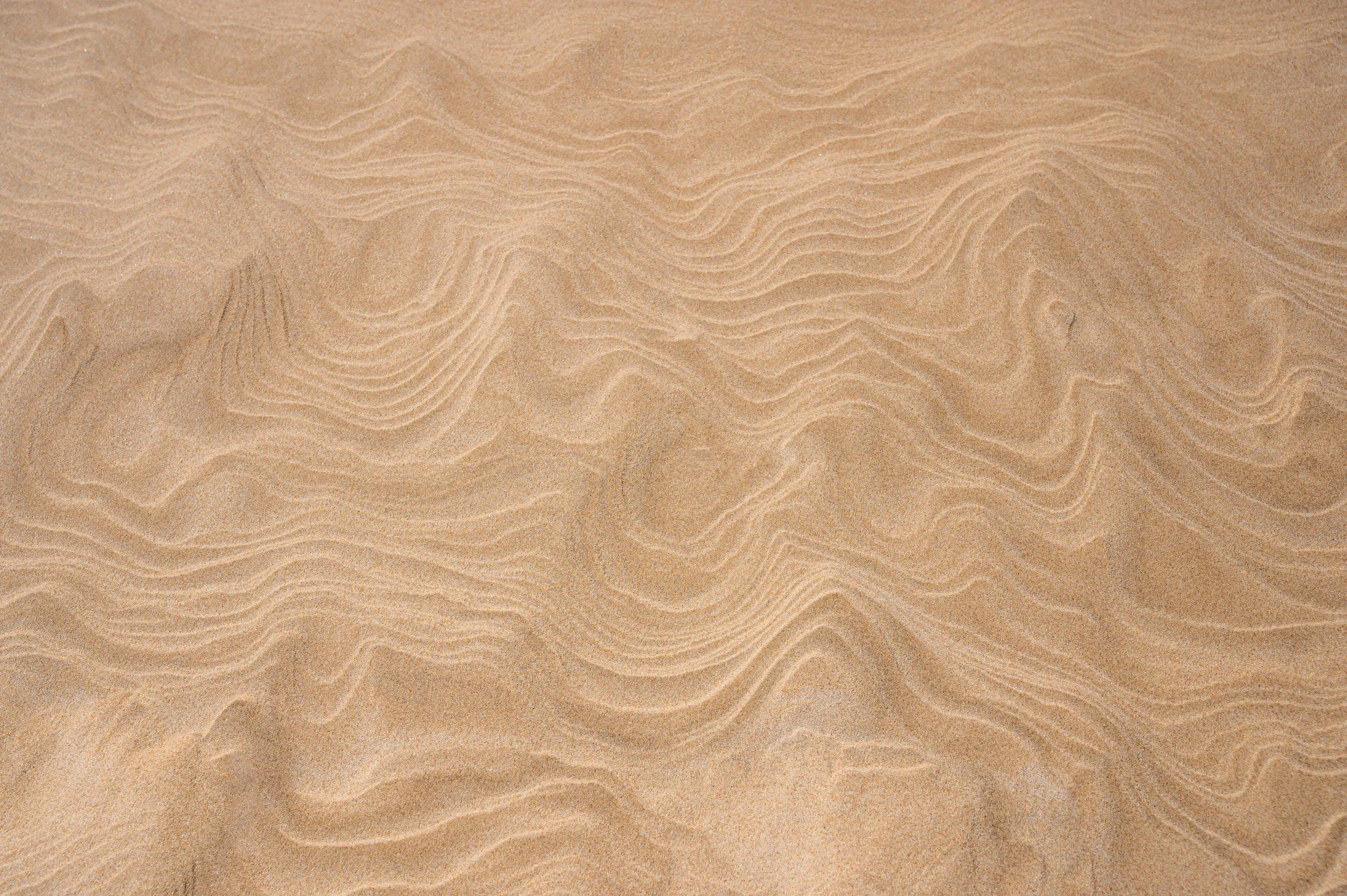 Close-up of sand dunes with wind-shaped patterns. Sandtray therapy