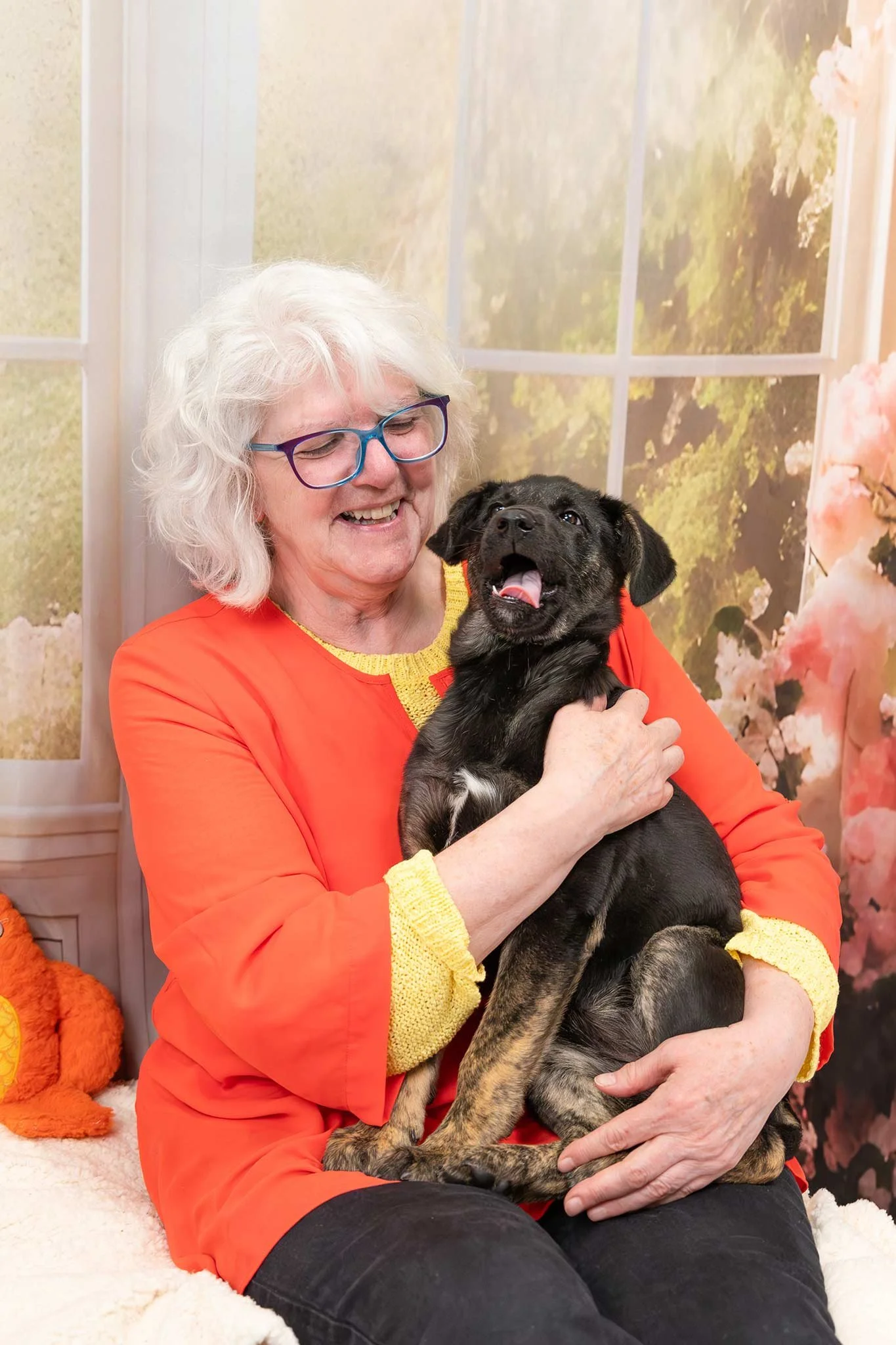 Dog Mom hugs her puppy and laughs while her puppy makes a funny face