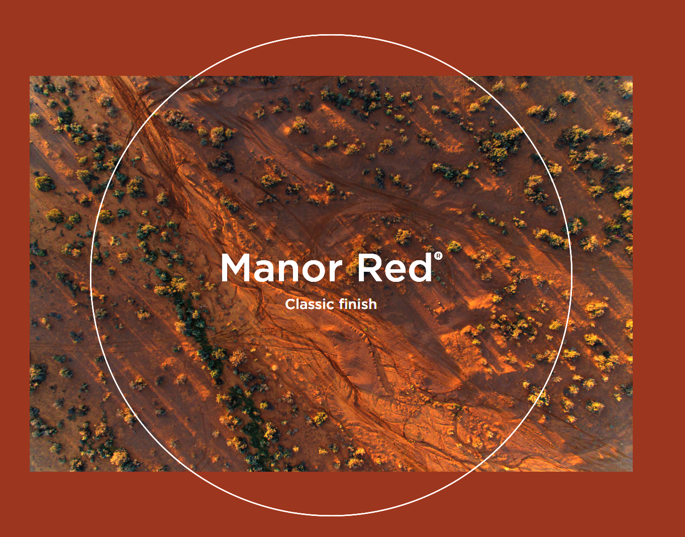 Aerial view of a desert landscape with reddish-brown soil and sparse vegetation, showing trails or pathways. Overlaying text reads 'Manor Red® Classic finish'.