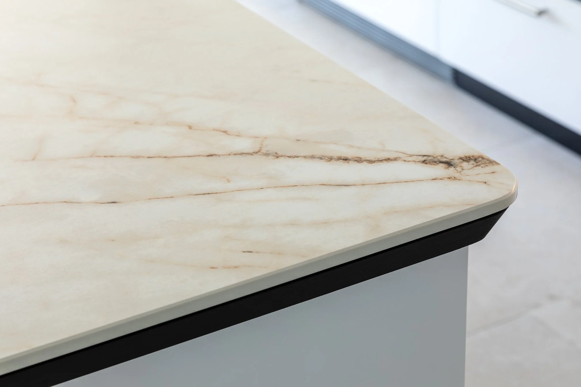 Close-up of a marble countertop with a beveled edge in a modern kitchen.