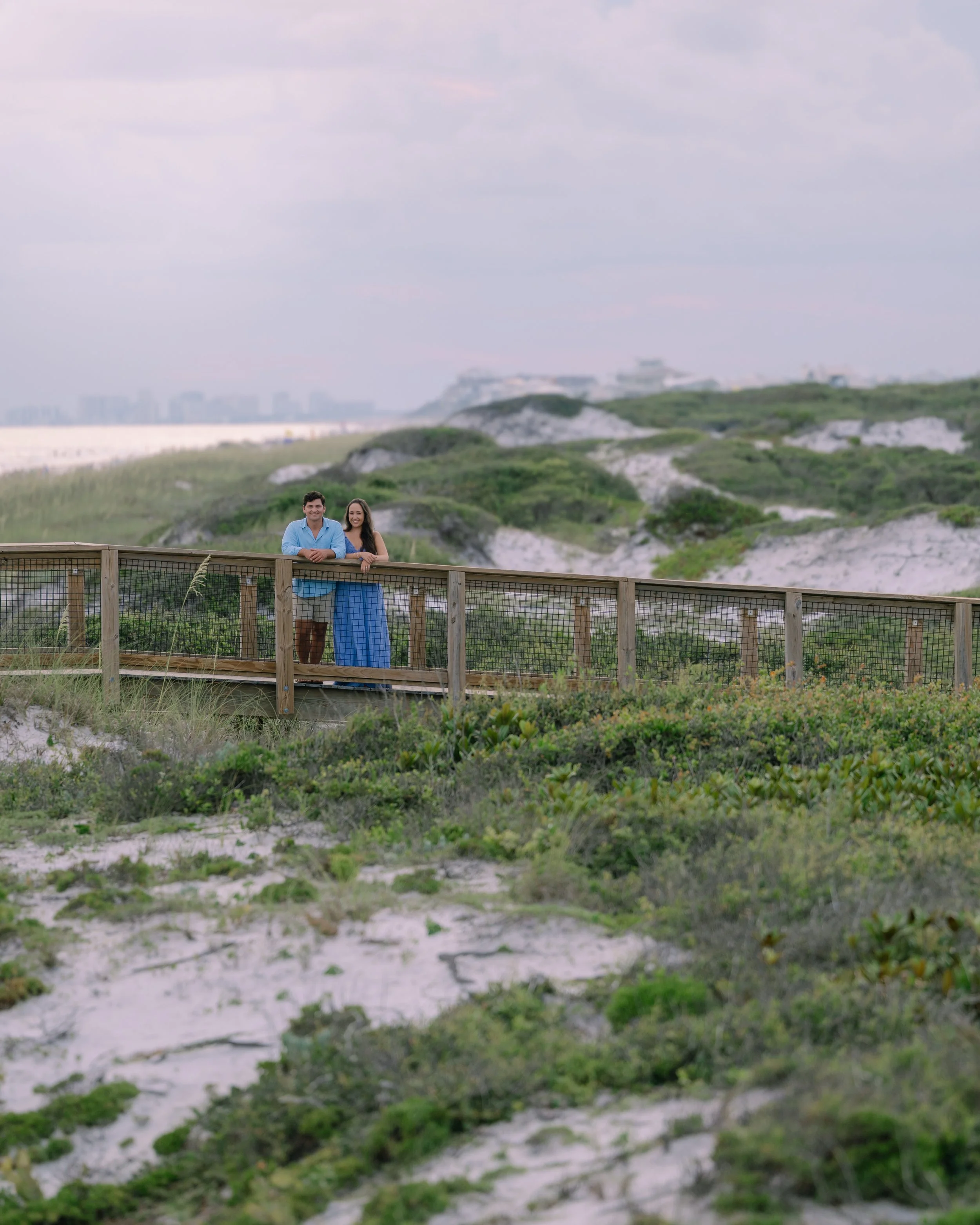 Man and Woman standing on a bridge over the dunes in Watercolor, Florida. 30A Photographer