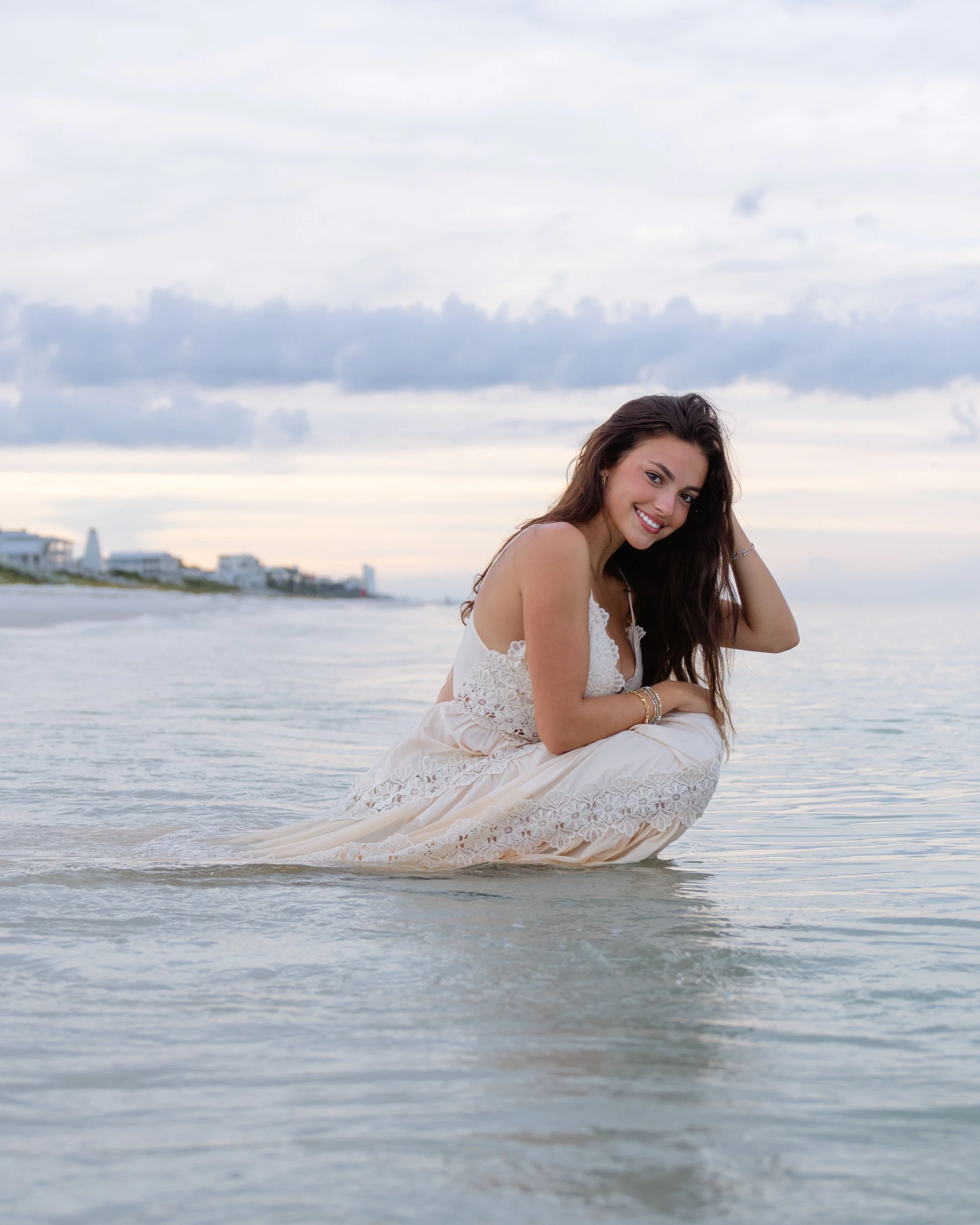 Girl in a dress posing in the shallow water at sunrise. 30A Photographer