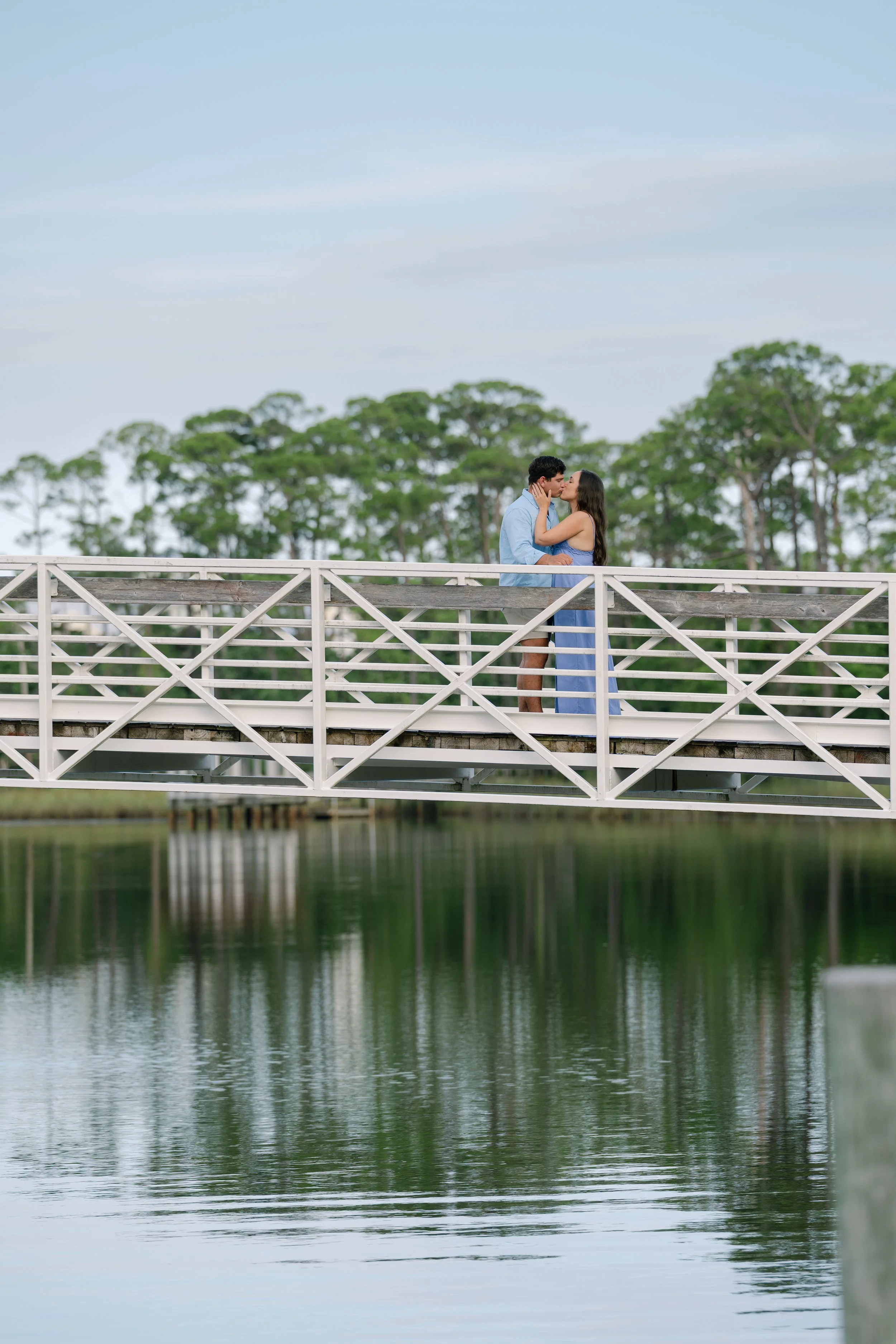Man and Woman stand on bridge over dune lake in Watercolor, Florida. 30A Photographer