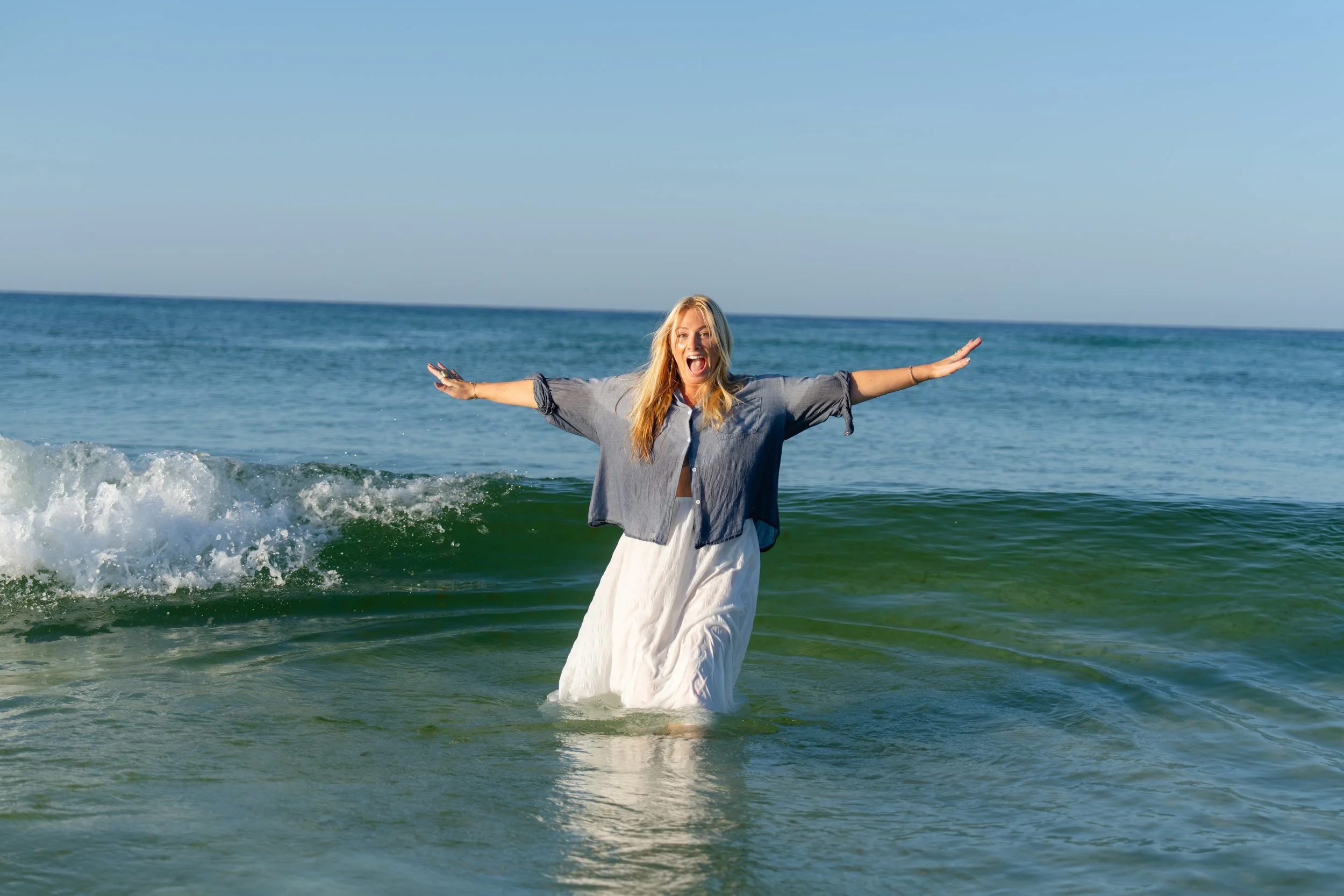 Portrait of a woman laughing and falling into the waves in Grayton Beach. Grayton Beach Photographer. 30A Photographer