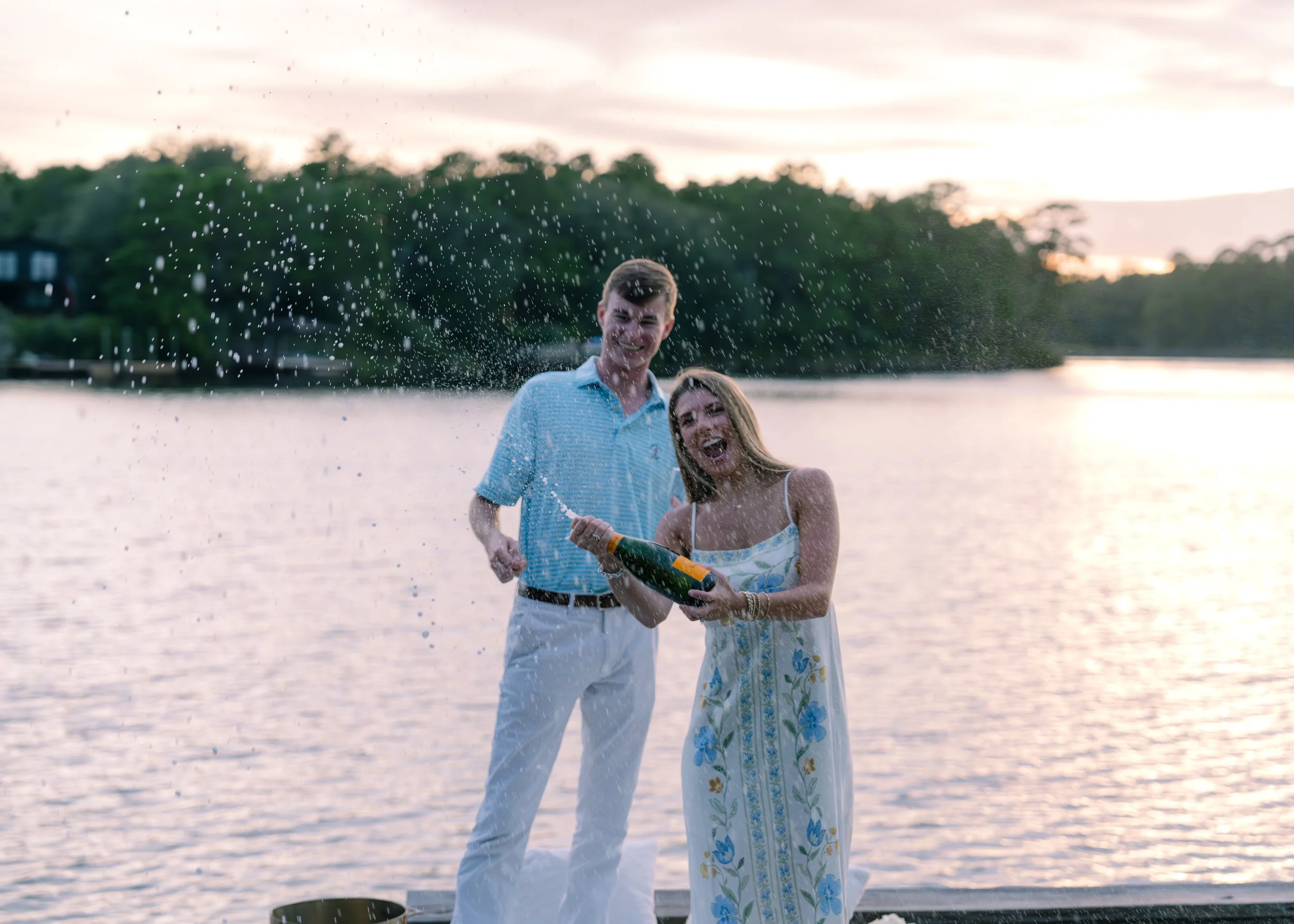 Man and woman popping champagne in the sunset. 30A Photographer