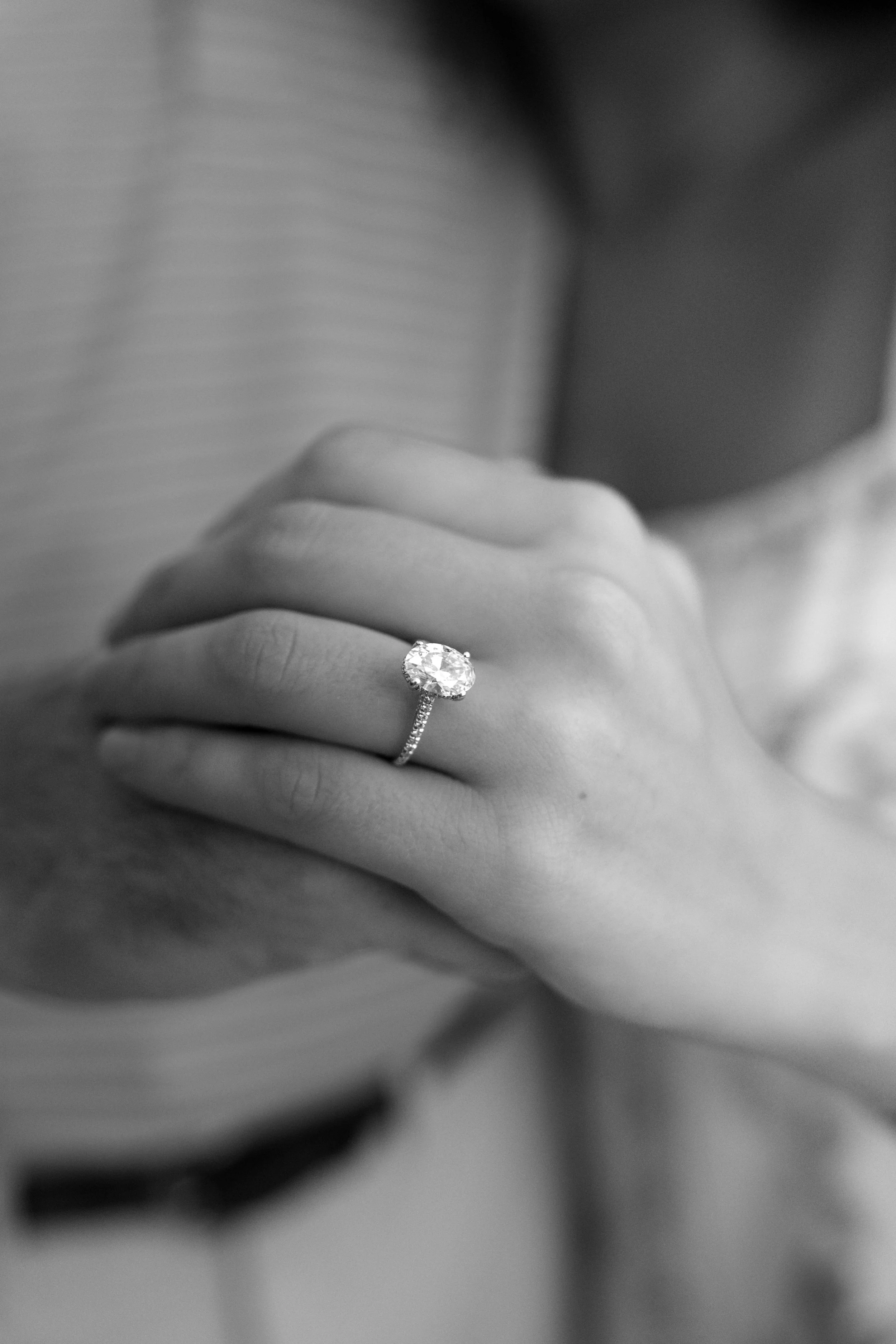 Man and woman holding hands showing their engagement ring. 30A Photographer