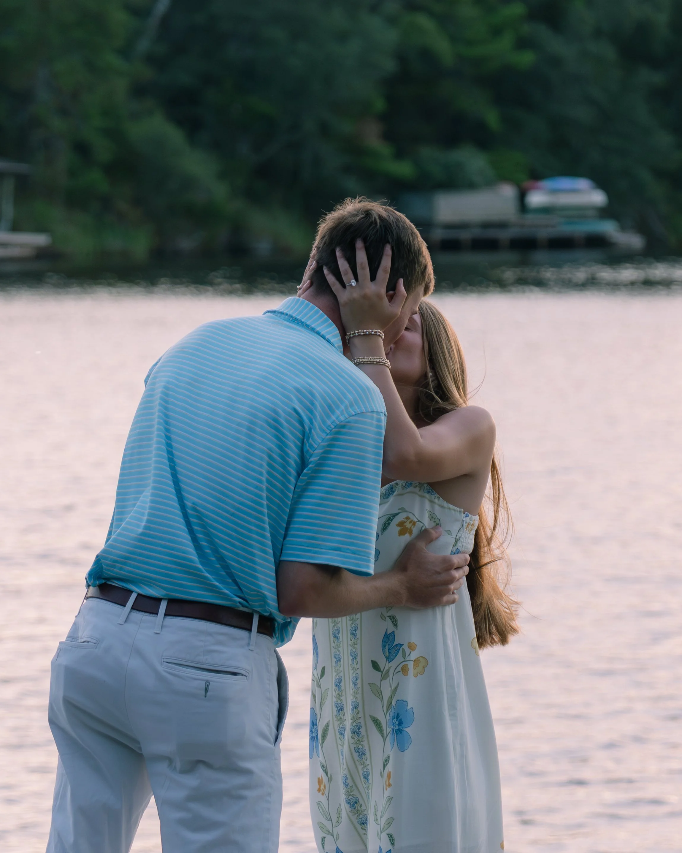 Man and woman kissing at sunset showing engagement ring. 30A Photographer