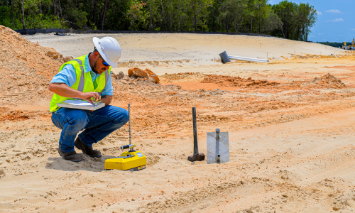 Soil engineer testing the density of the compacted matyerial.
