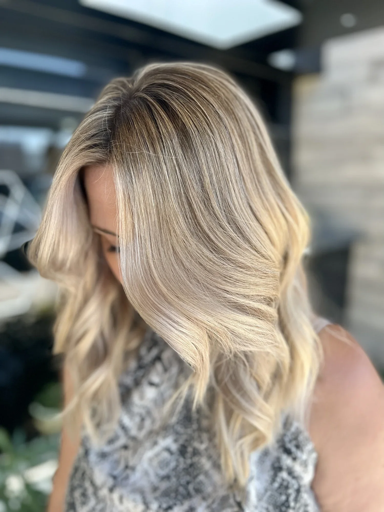 Close-up of a woman's blonde, wavy hair styled with soft curls.