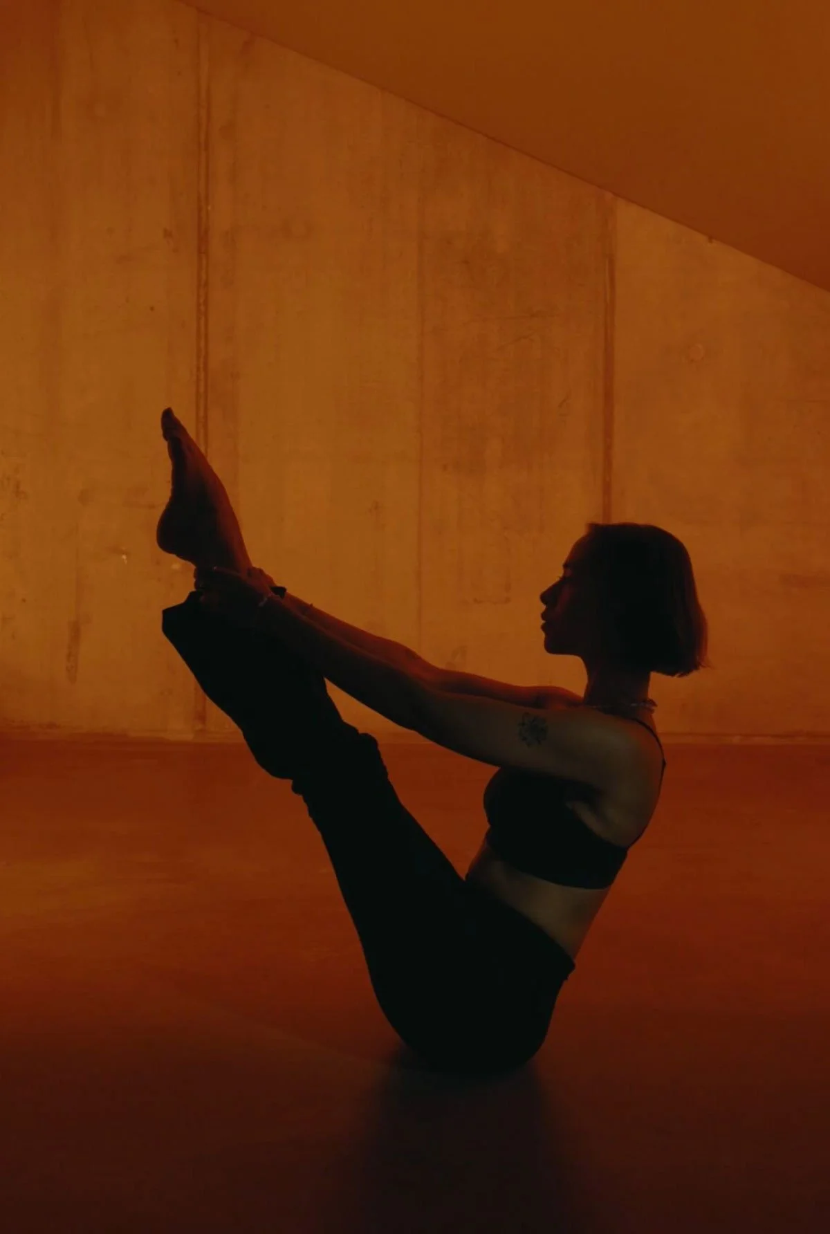 Pilates "Teaser" pose in ambient lighting