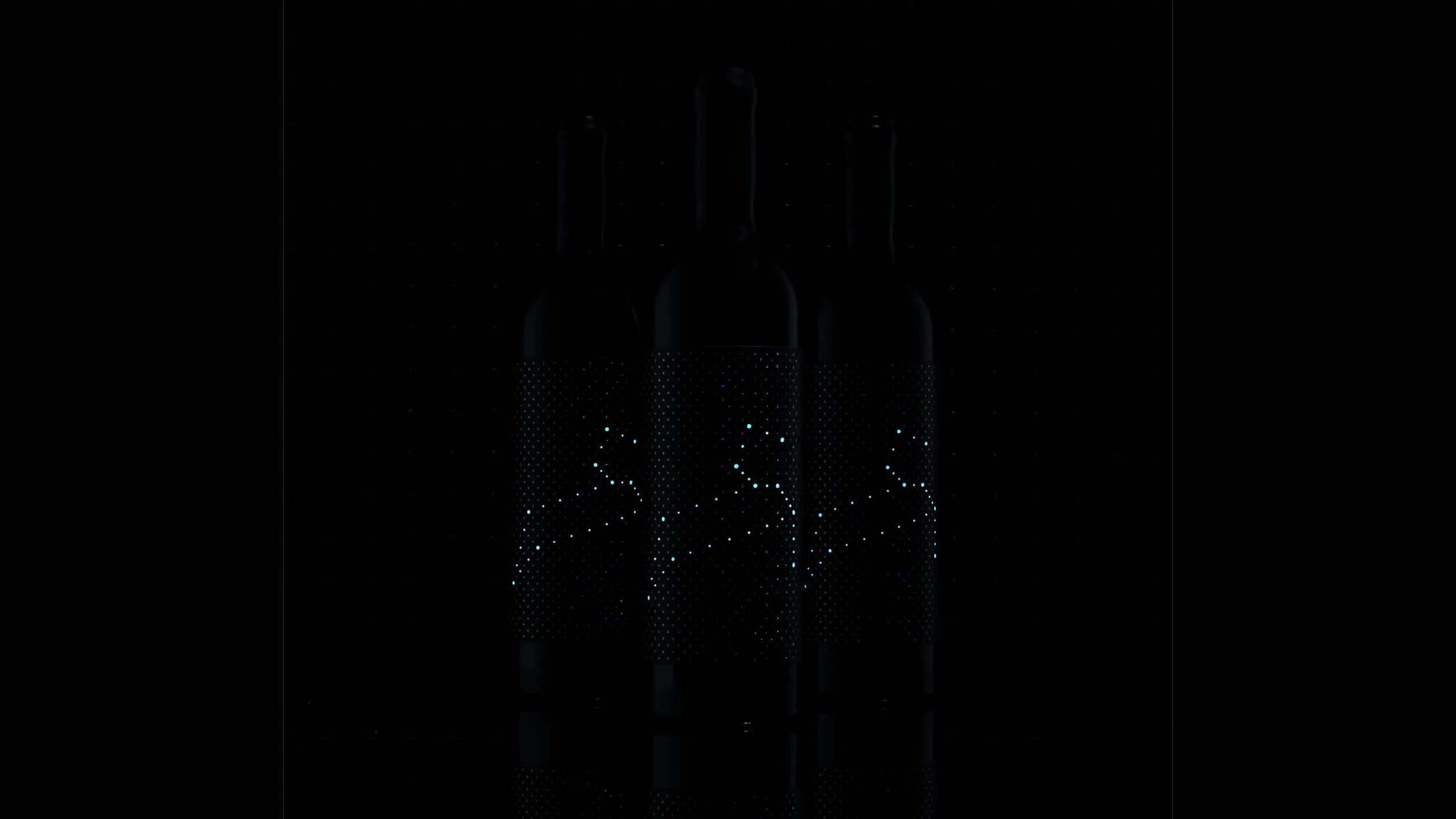 Four Nightfall Wines black wine bottles with black labels featuring a pattern of small, evenly spaced white dots, standing in a row on a reflective surface with a black background.