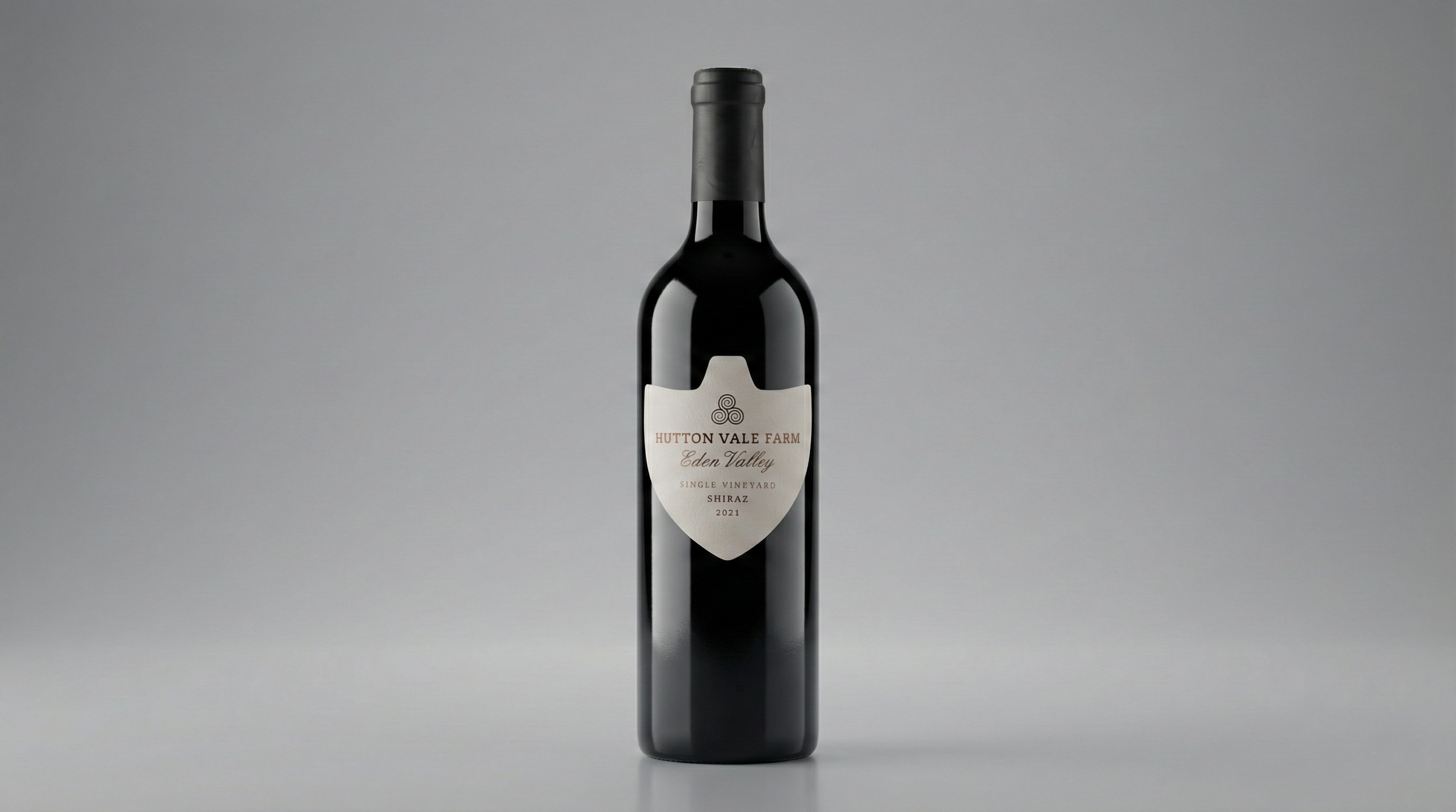 A bottle of Hutton Vale Farm Eden Valley single vineyard Shiraz wine from 2021, standing upright on a plain gray background.