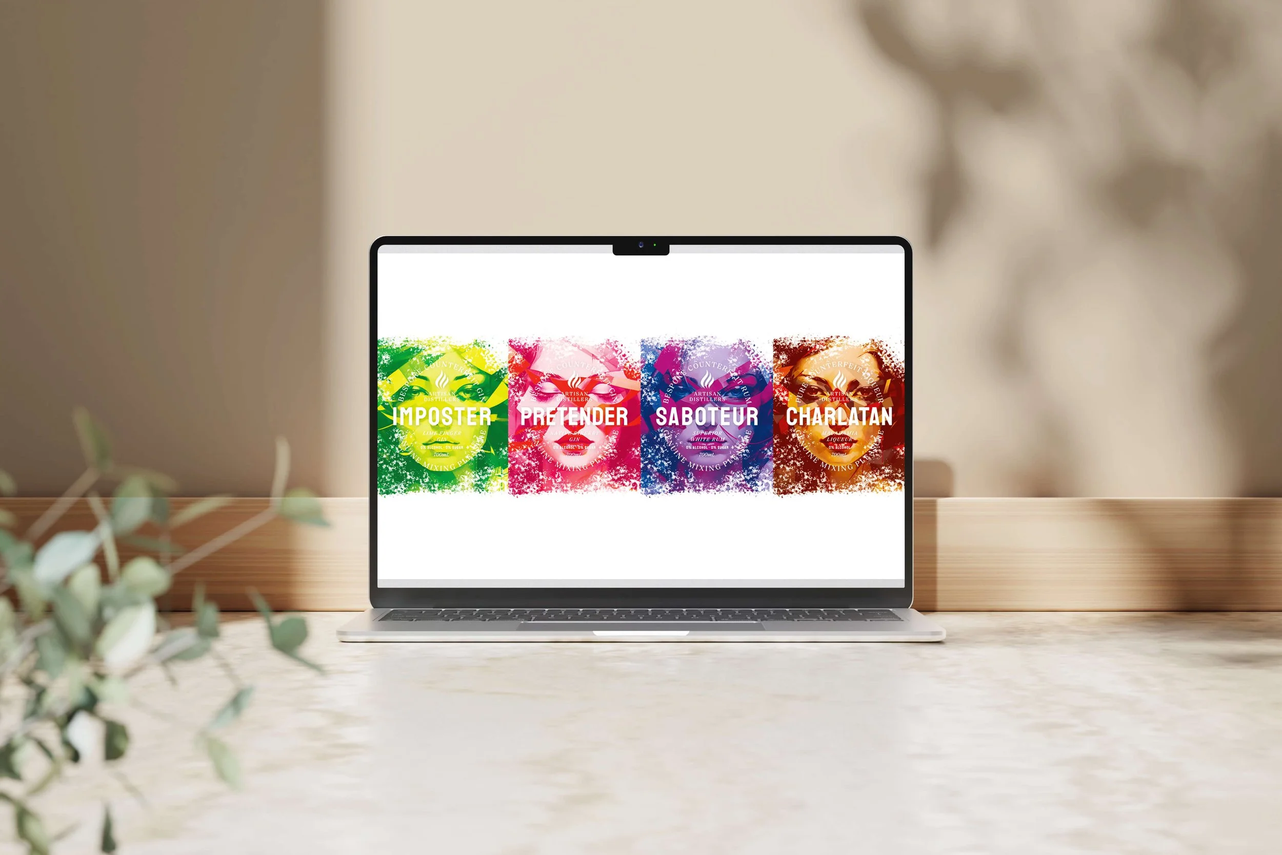 Laptop displaying four colourful back wine labels named Imposter, Pretender, Saboteur, and Charlatan, arranged from green to red, on a wooden table with a blurred background.