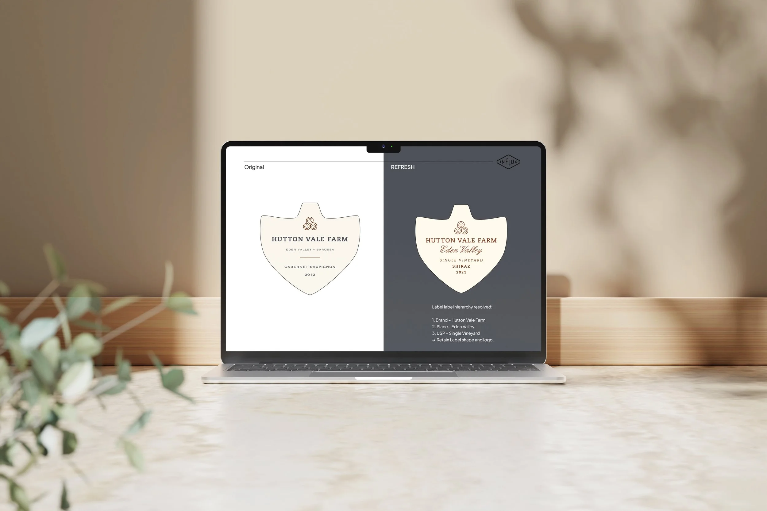 Laptop on a desk displaying a wine label design comparison for Hutton Vale Farm, Eden Valley, showing original and refreshed versions.