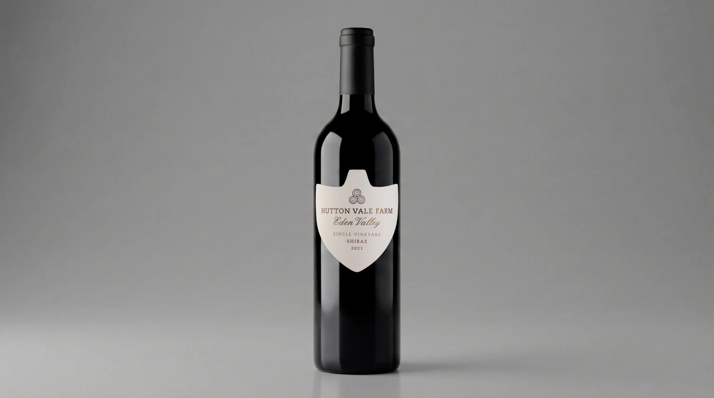 A bottle of red wine with a white label that reads "Hutton Vale Farm Eden Valley Single Vineyard Shiraz 2021" against a plain gray background.