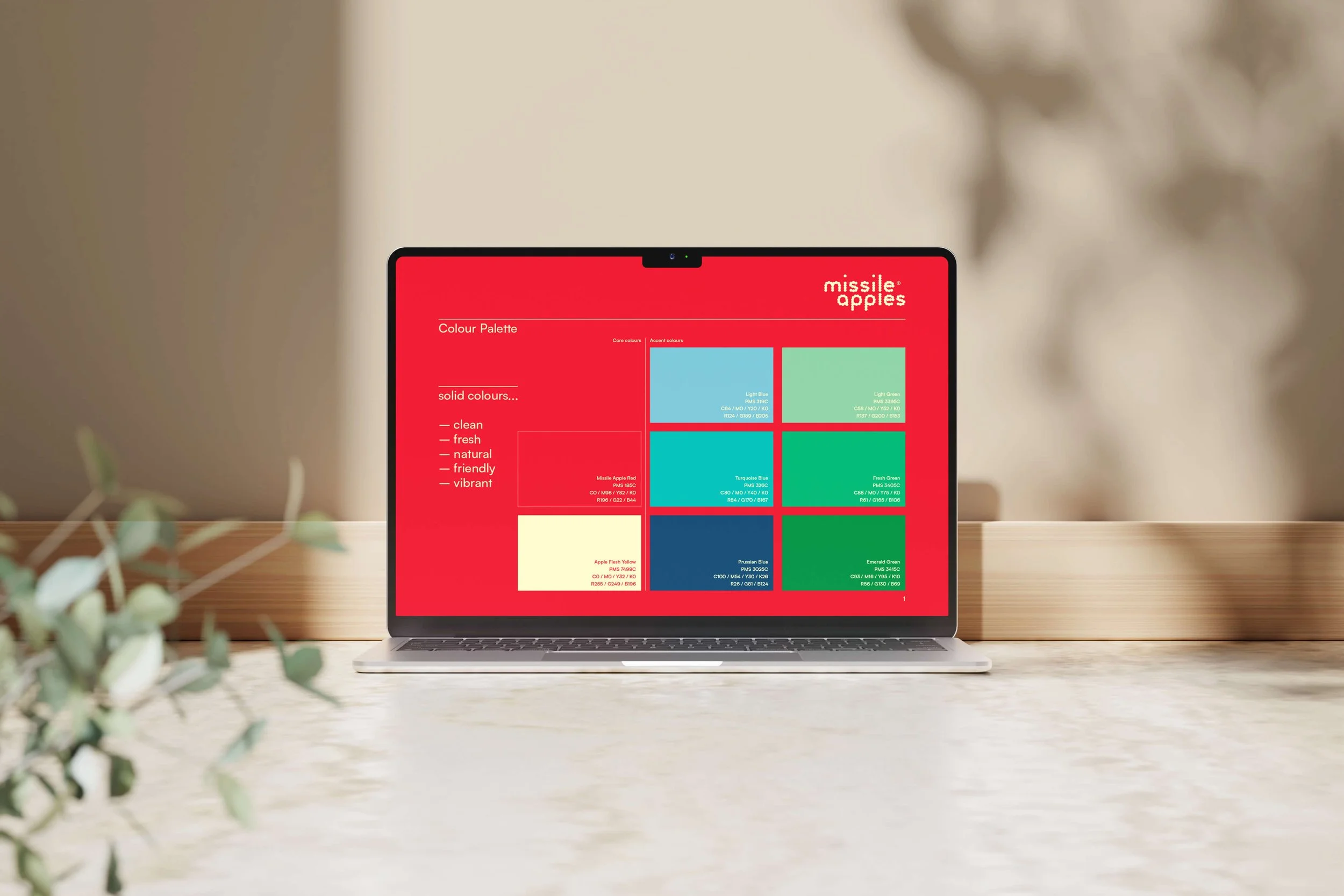 Laptop displaying a color palette for Missile Apples with various colors and descriptions on a wooden desk.