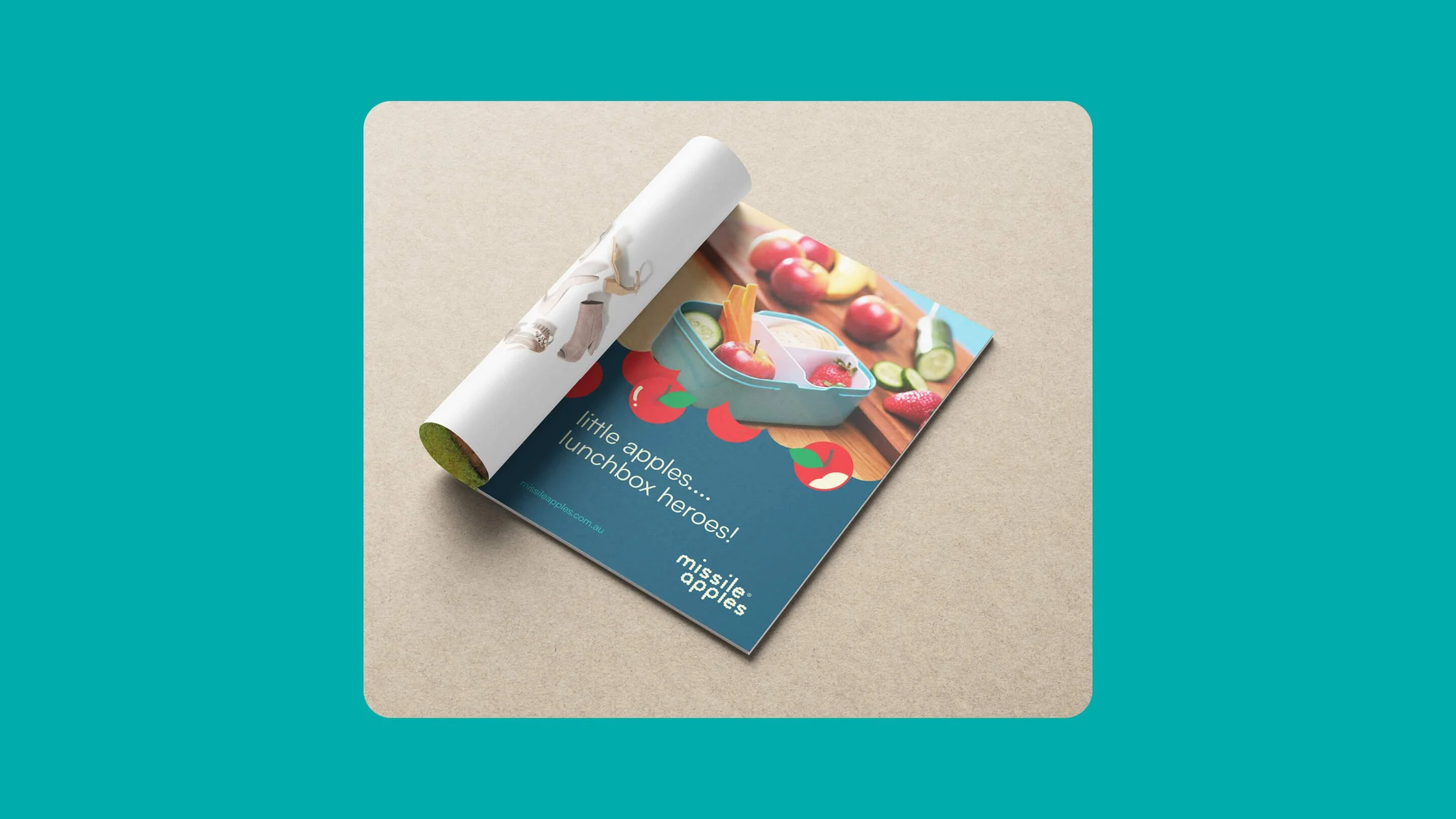 A colorful flyer promoting missile apples lunchbox heroes, showing a lunchbox with apple-shaped containers, surrounded by fresh apples and vegetables, with the text 'little apples... lunchbox heroes!'.