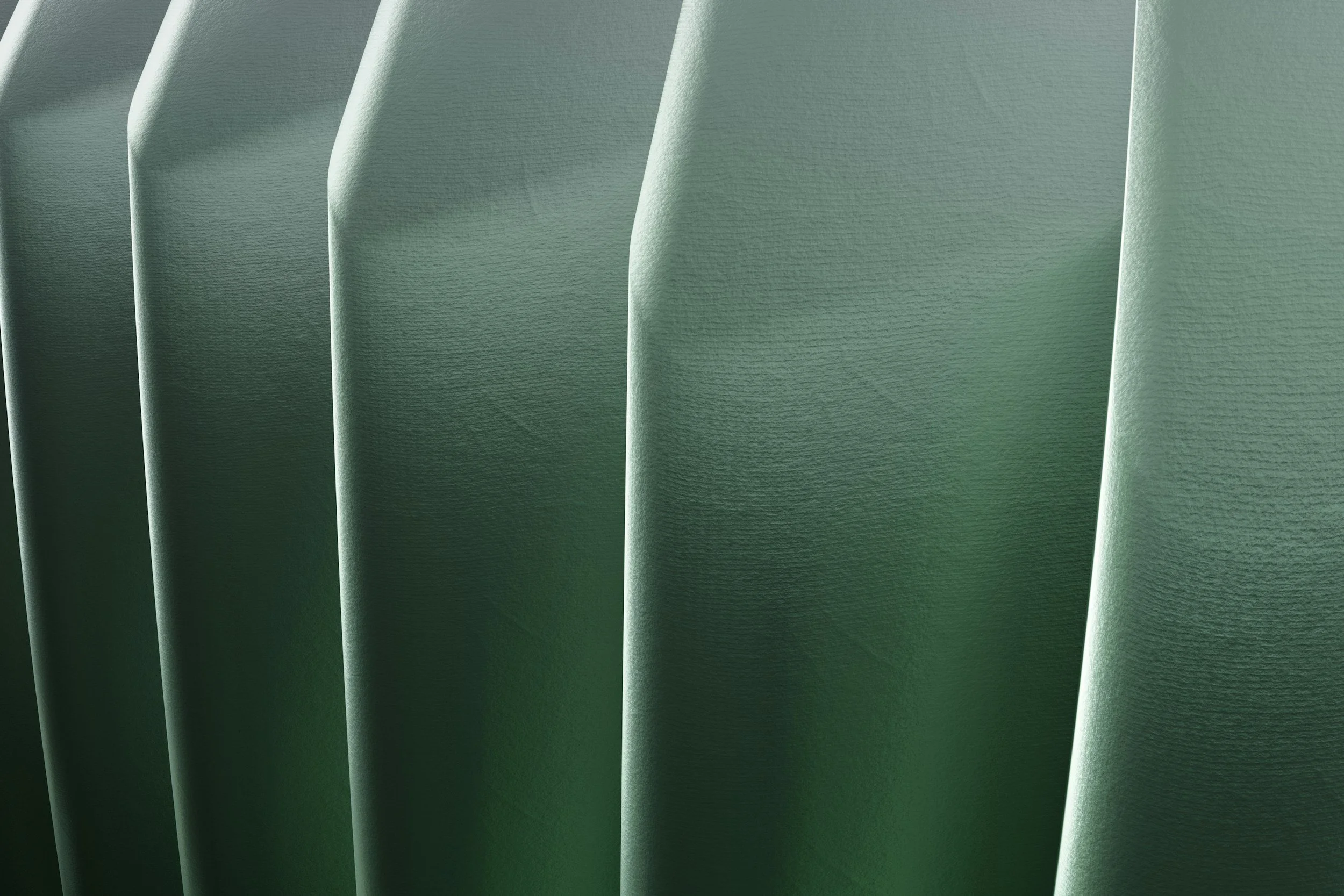 Nahaufnahme grüne Stoffbahn mit Falten und Textur.