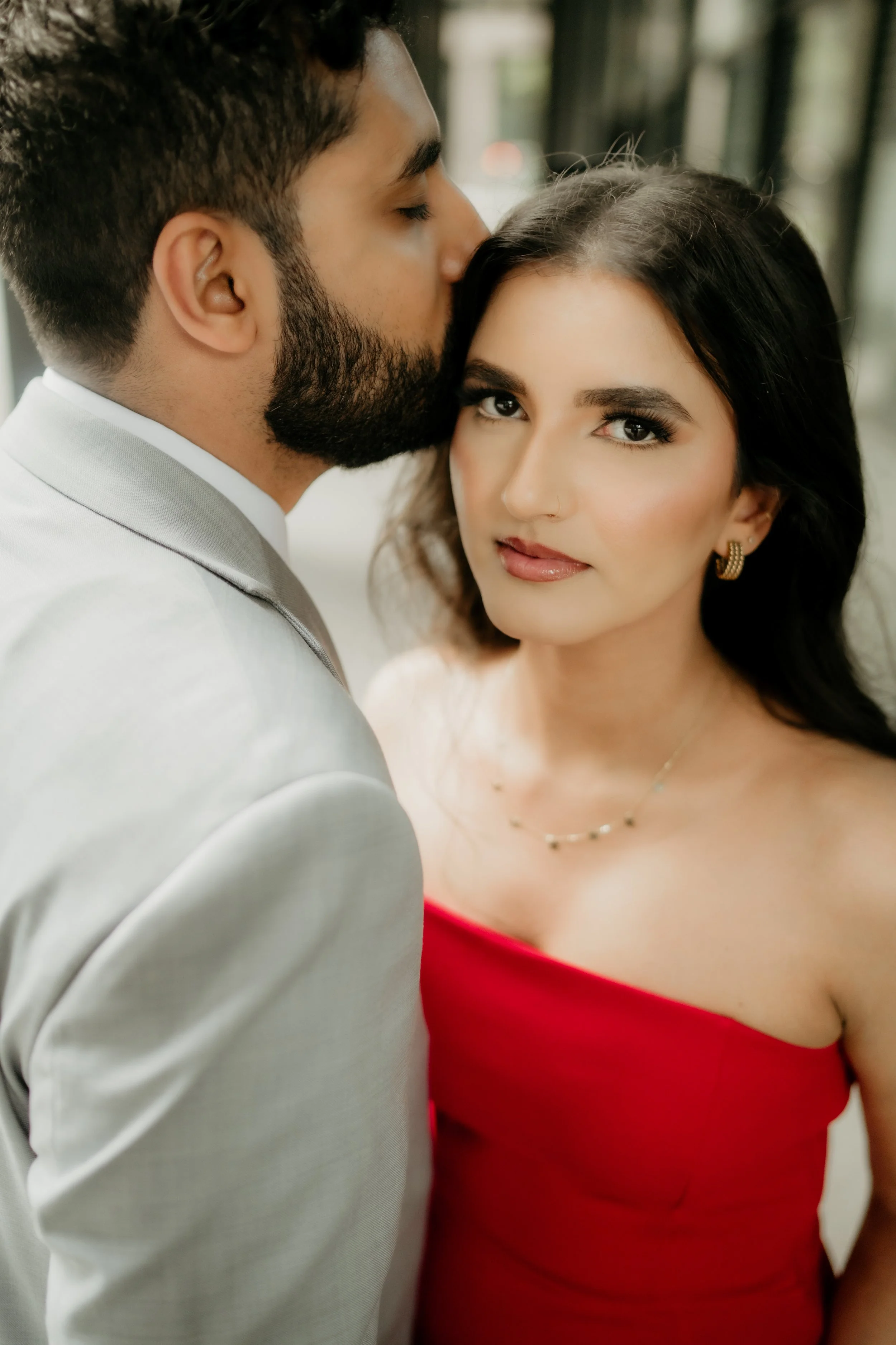 A mountain landscape with snow-capped peaks, green rolling hills, and a modern building in the foreground.
