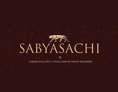 Sabyasachi logo with a golden tiger and the tagline 'Golden elegance: a wall lamp of Indian splendor'