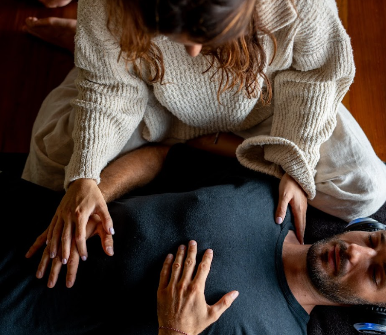 A woman practicing yoga in a studio, performing downward dog pose on a yoga mat.