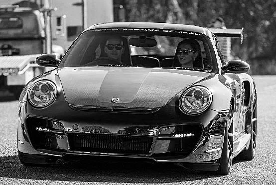 Nik and Aika Seirlis driving their Porsche GT supercar, representing the passion and expertise behind Supercar Finance Australia.