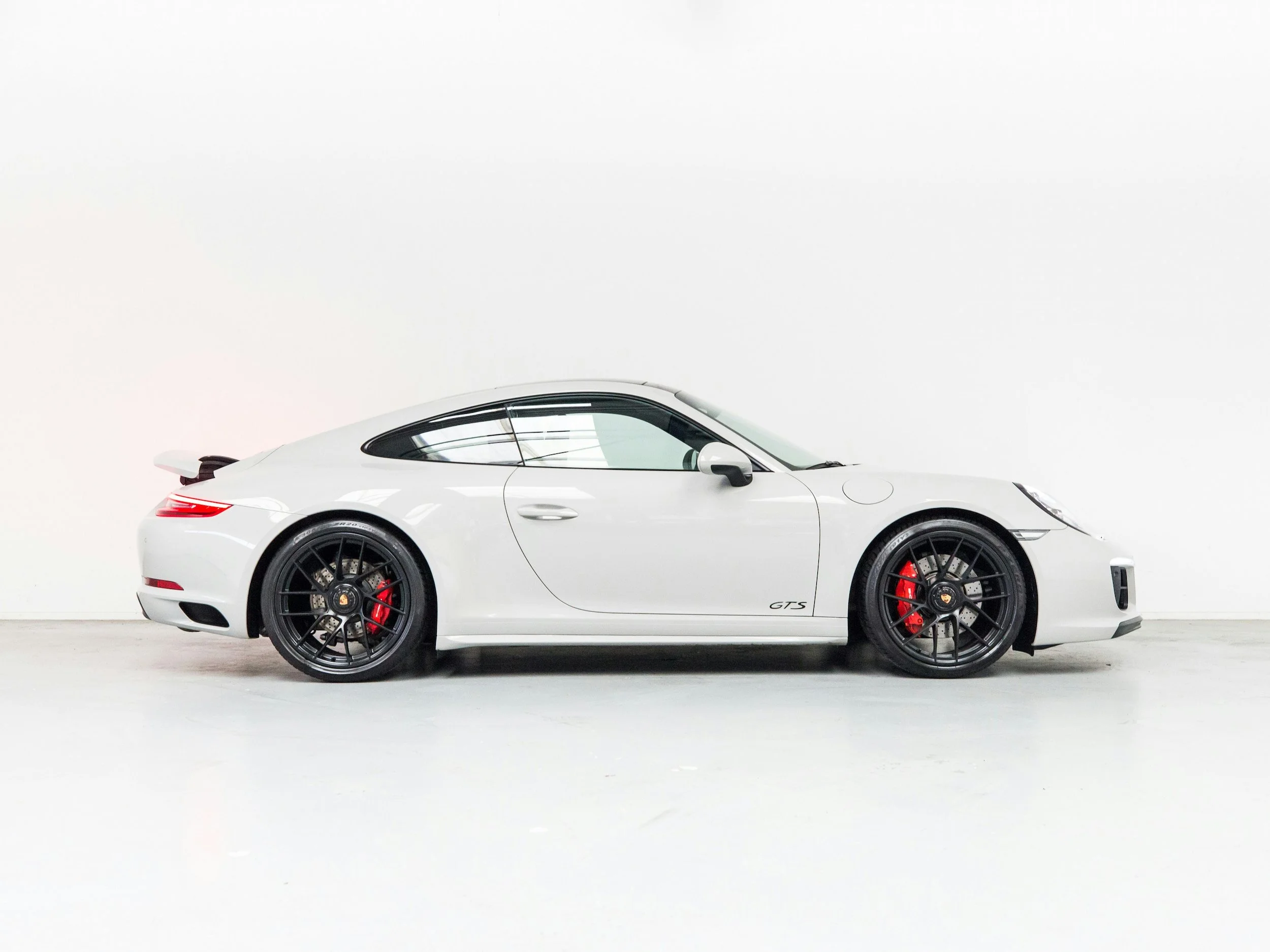 White Porsche 911 GTS photographed in a clean studio setting, representing the type of prestige performance vehicles commonly financed through tailored supercar finance options in Australia.