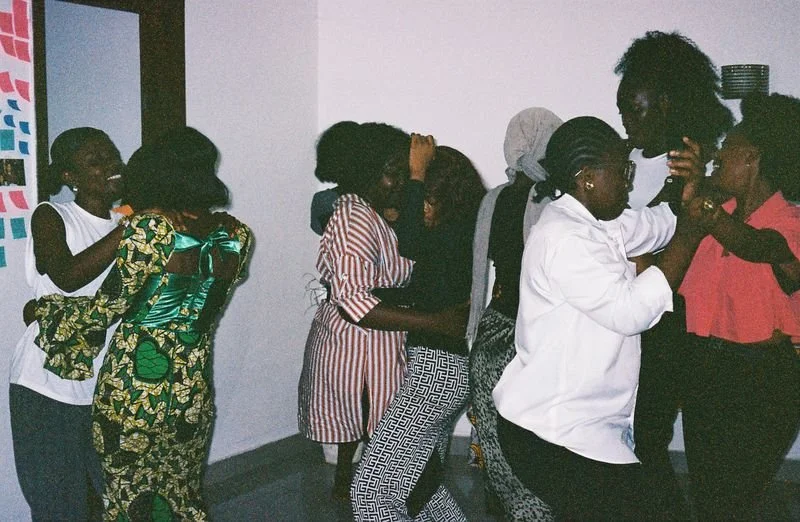 People dancing and socializing at an indoor gathering.
