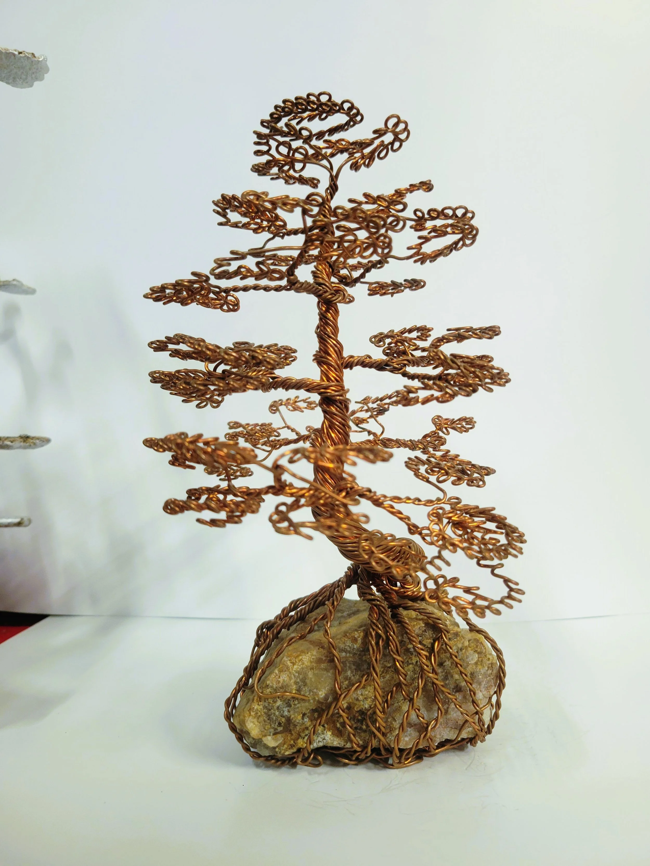 Wire sculpture of a tree on a rock base