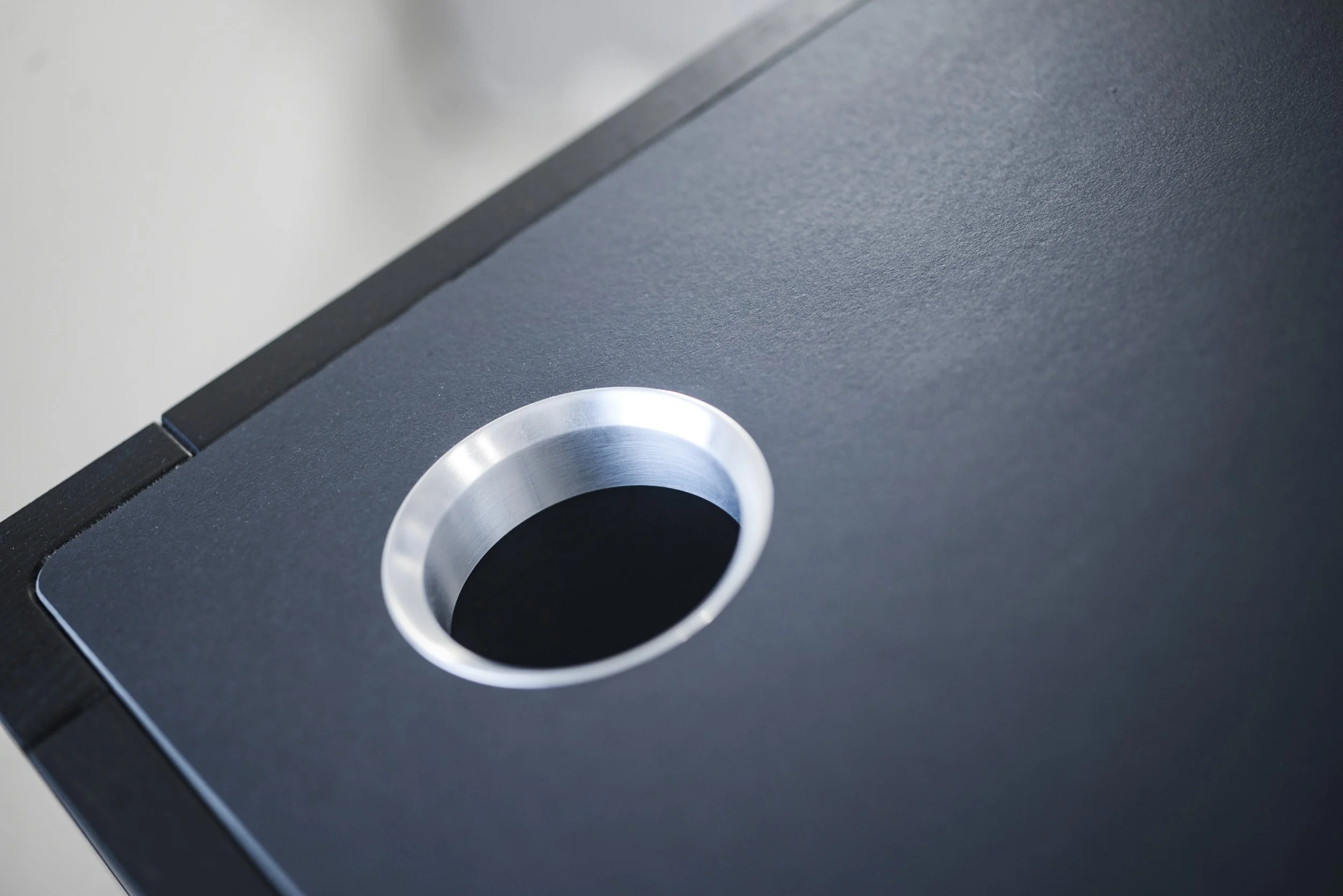 Close-up of a black speaker with a silver circular port or hole.