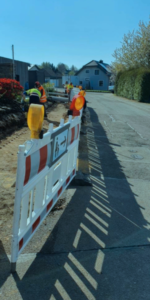 Trabajadores de construcción realizando obras en la calle, con señalización y equipo de seguridad