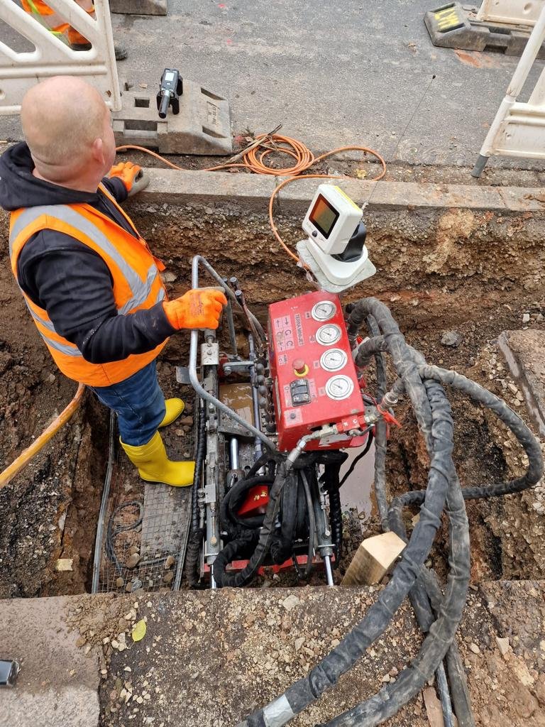 Explanación de maquinaria de construcción en una excavación en tierra con un tractor en segundo plano.