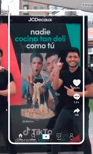 Popular TikTok video on a phone screen showing three men posing with a bowl of spaghetti, with a text overlay in Spanish that says 'nadie cocina tan deli como tú' meaning 'nobody cooks so delicious as you'.