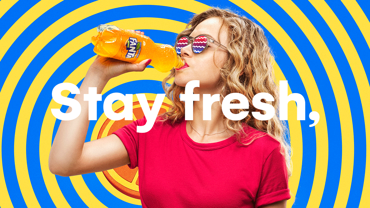 A woman with curly blonde hair wearing sunglasses and a red shirt is drinking orange soda from a Fanta bottle against a colorful swirl background with the words "Stay fresh," overlaid.