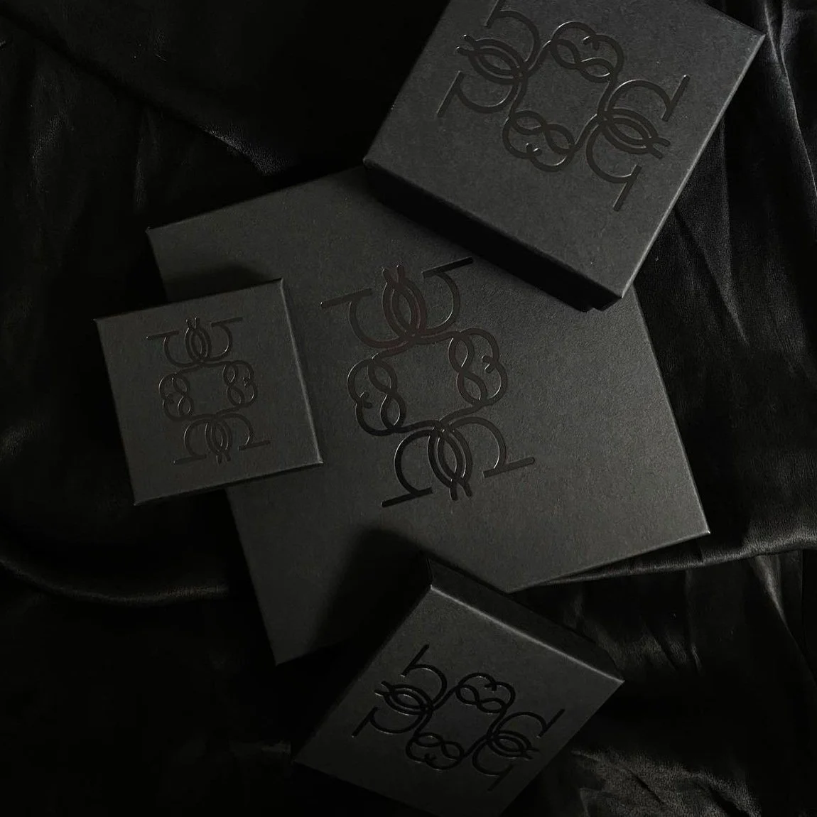 Luxury black boxes with a glossy logo on the lids, luxury packaging for high-end jewellery