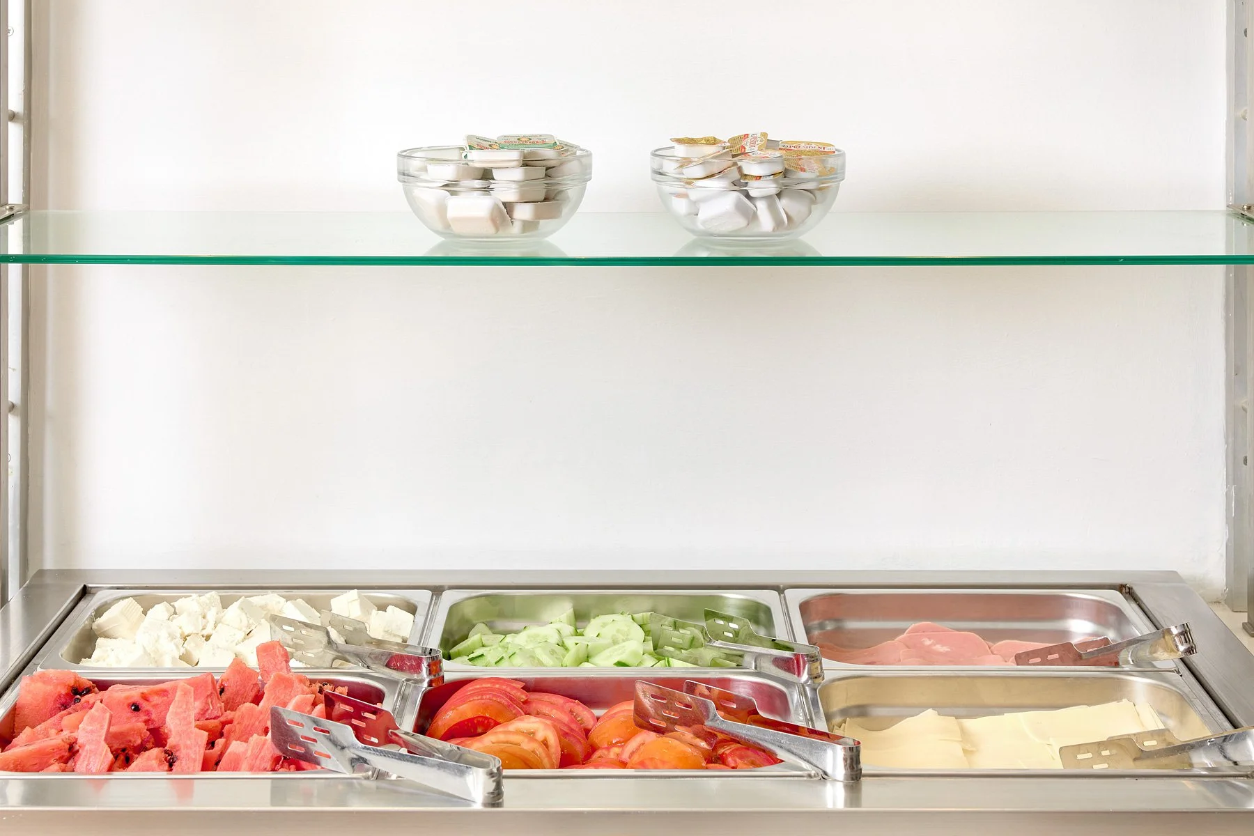 Ice cream toppings and fresh fruits in a buffet station.