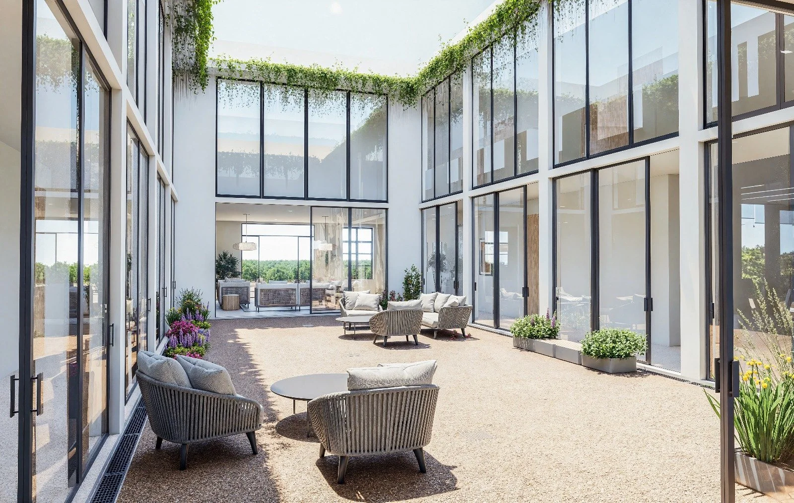 Indoor patio with comfortable seating, large glass windows, and green plants