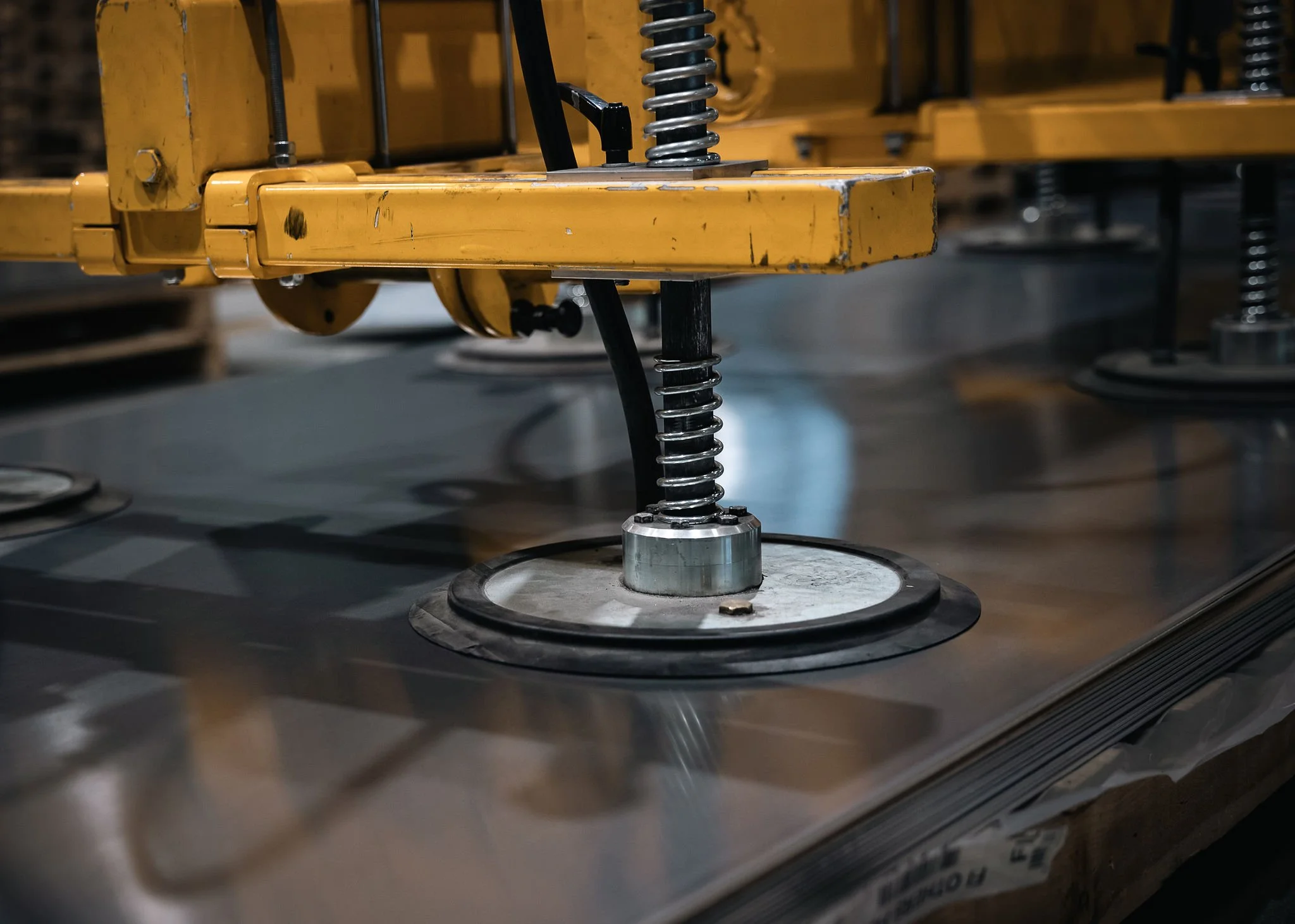 Alipainenostin nostamassa metallilevyä tuotantotilassa.