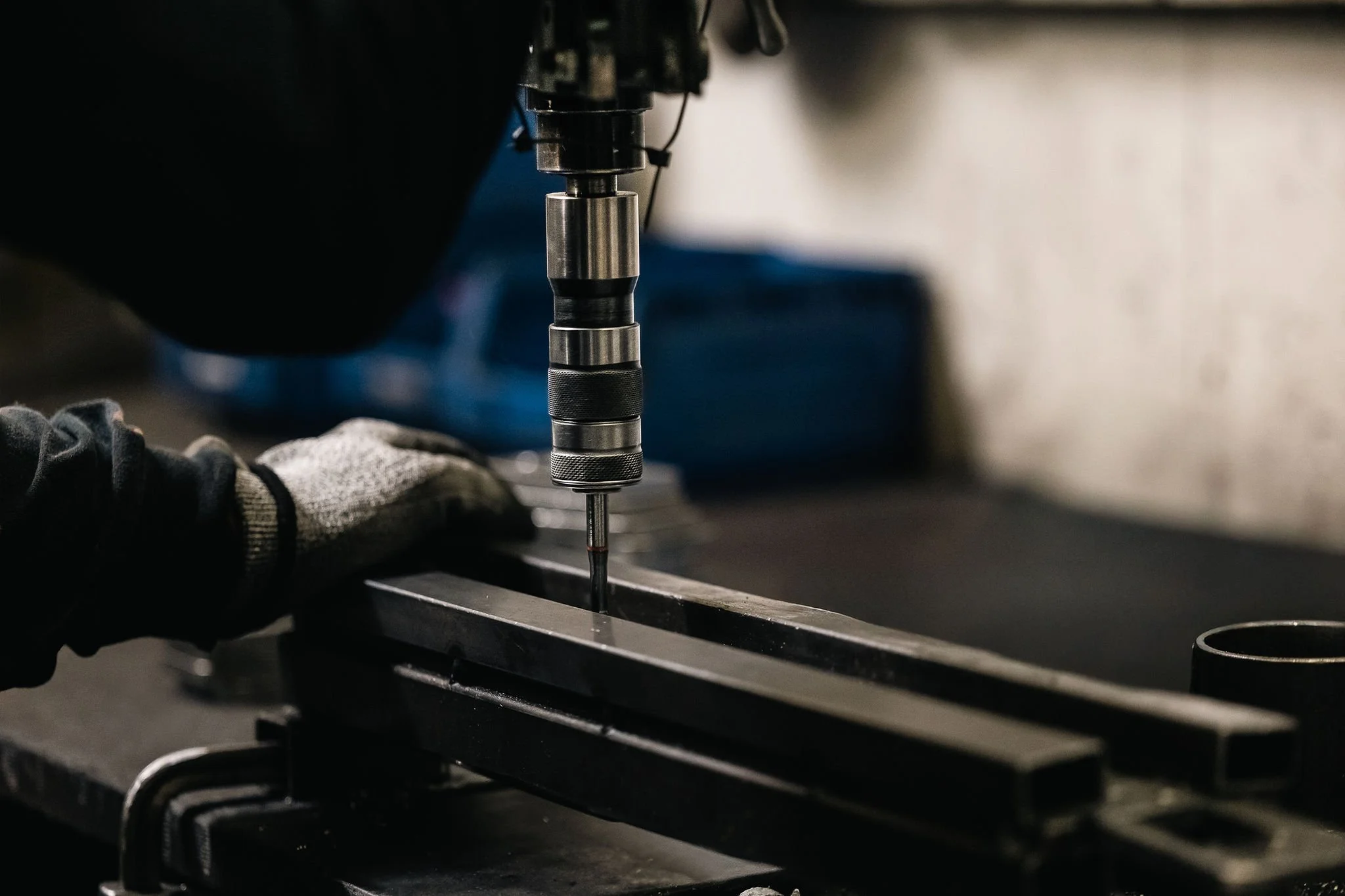 Työntekijä tekemässä kierrettä metalliosaan.