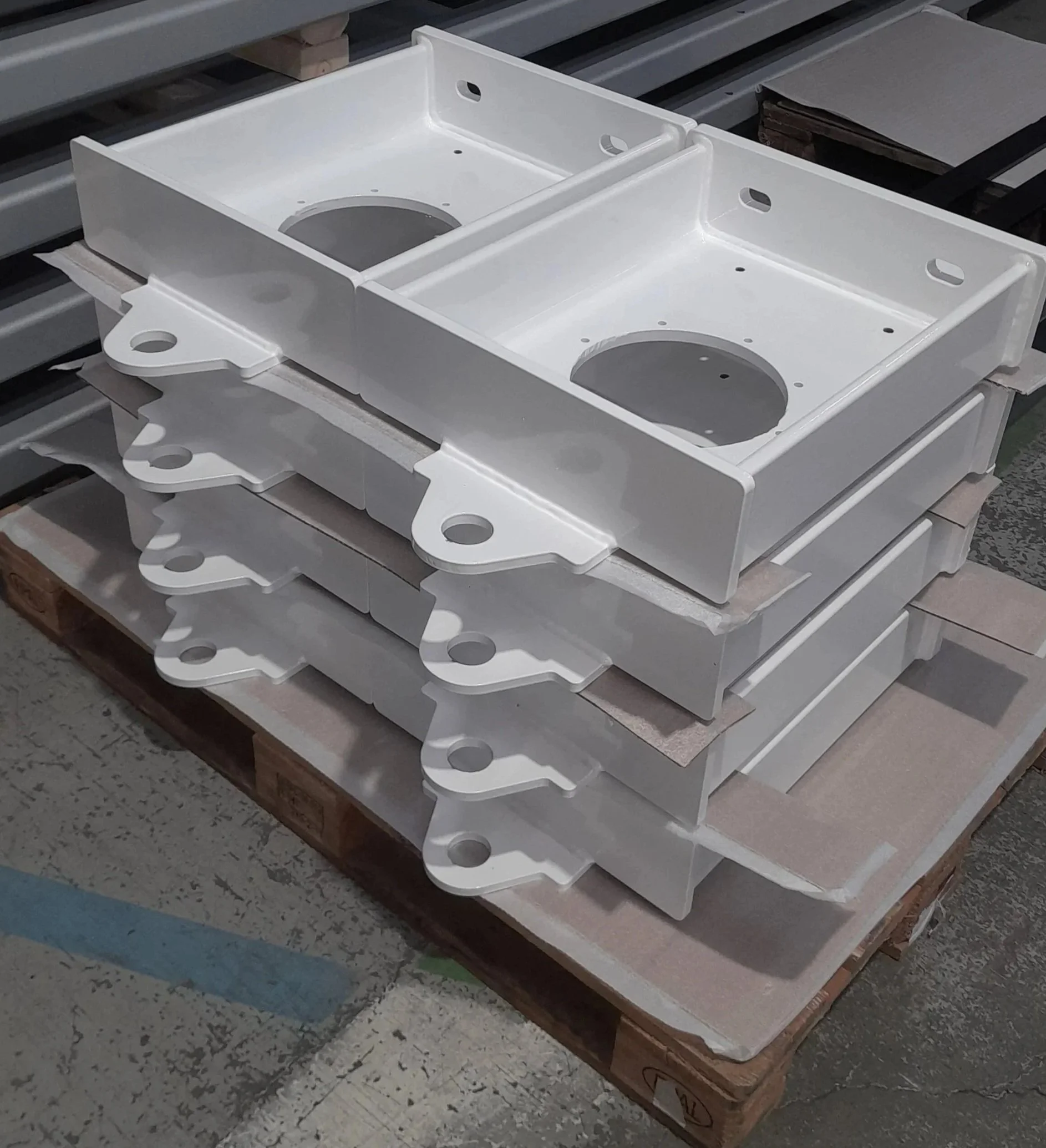 Pintakäsiteltyjä metalliosia pinottuna.