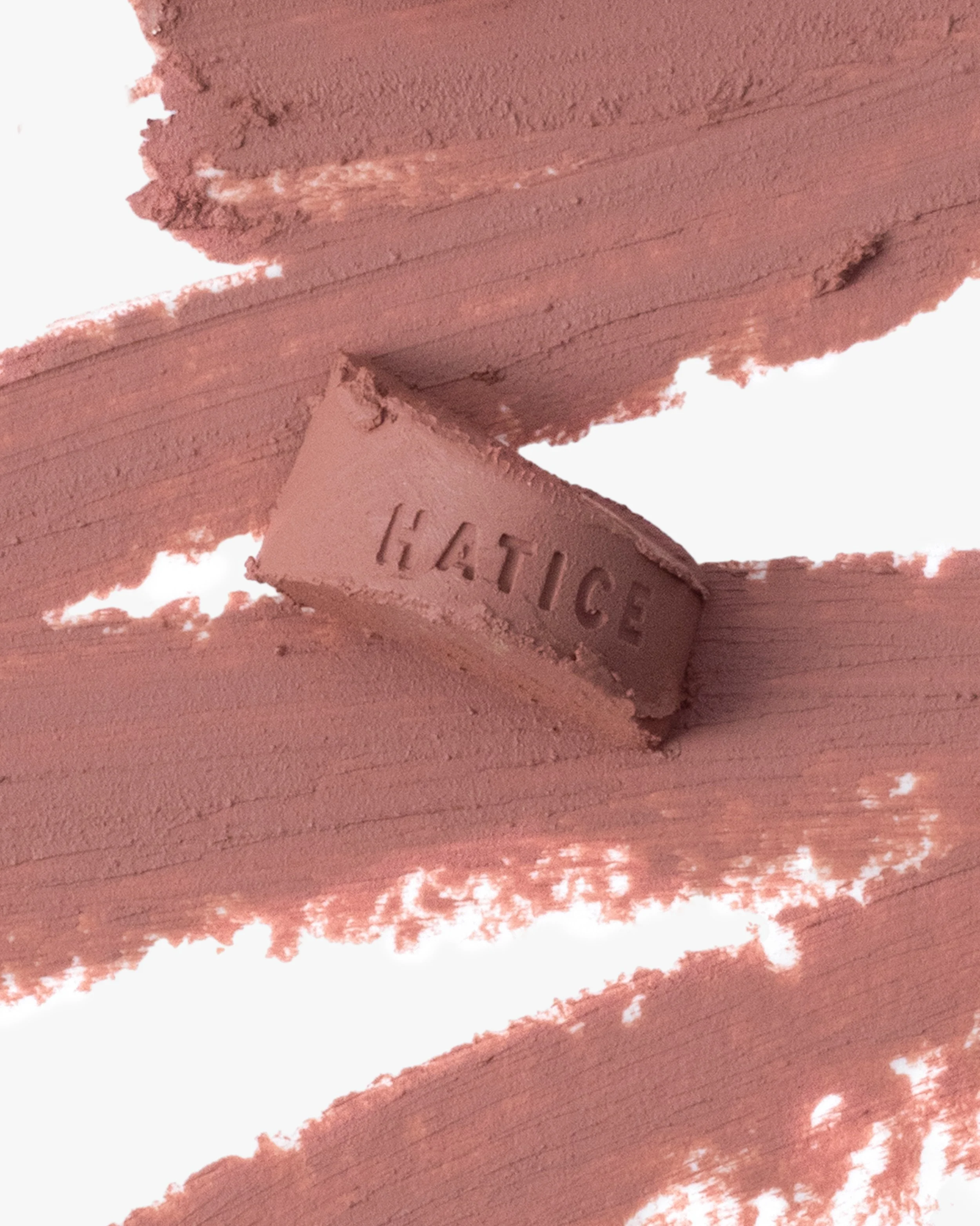 A pinkish-brown painted wooden surface with the word 'HATICE' engraved in a small, curved piece of wood.