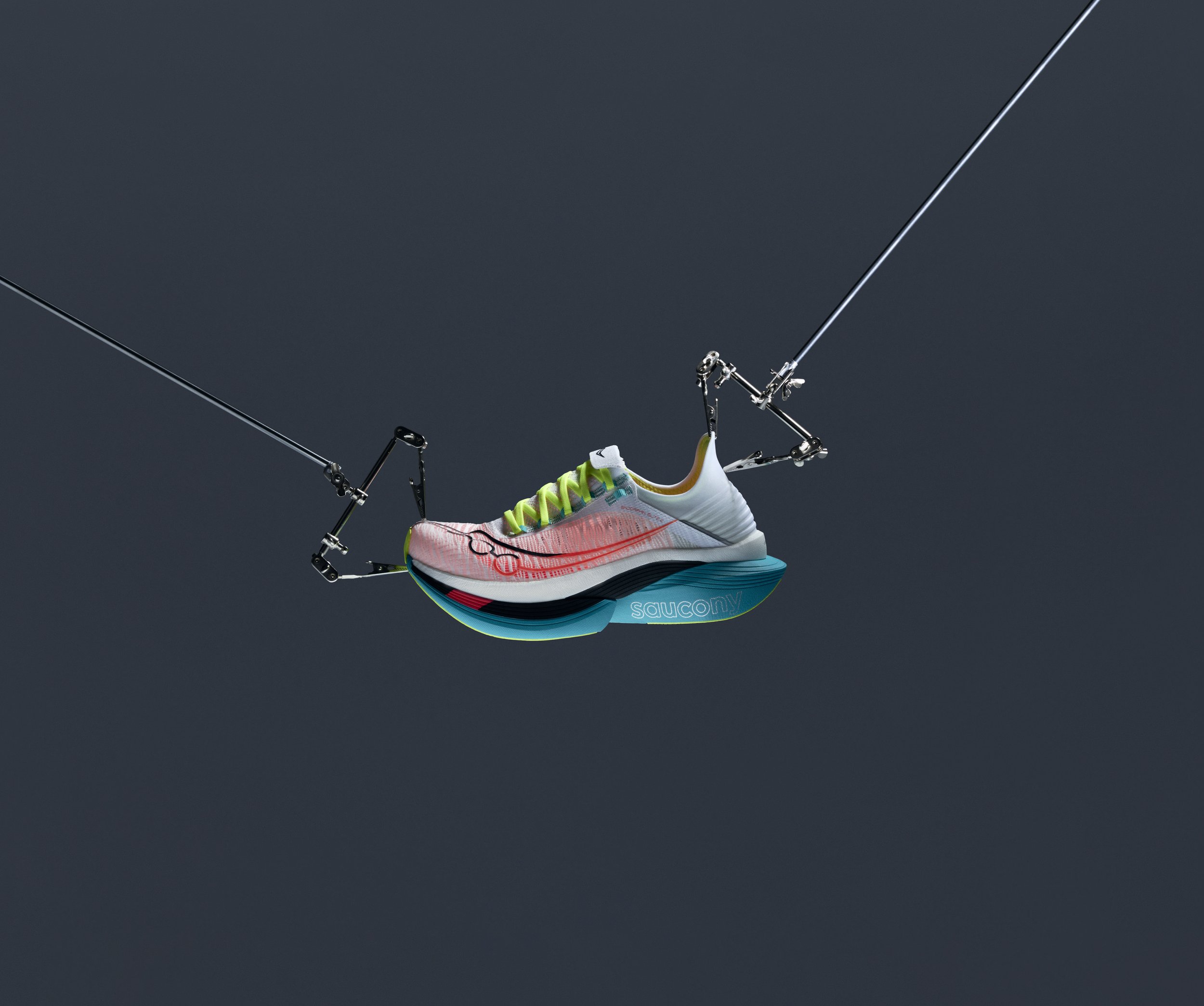A running shoe suspended by wires against a dark background, resembling a tightrope walker.