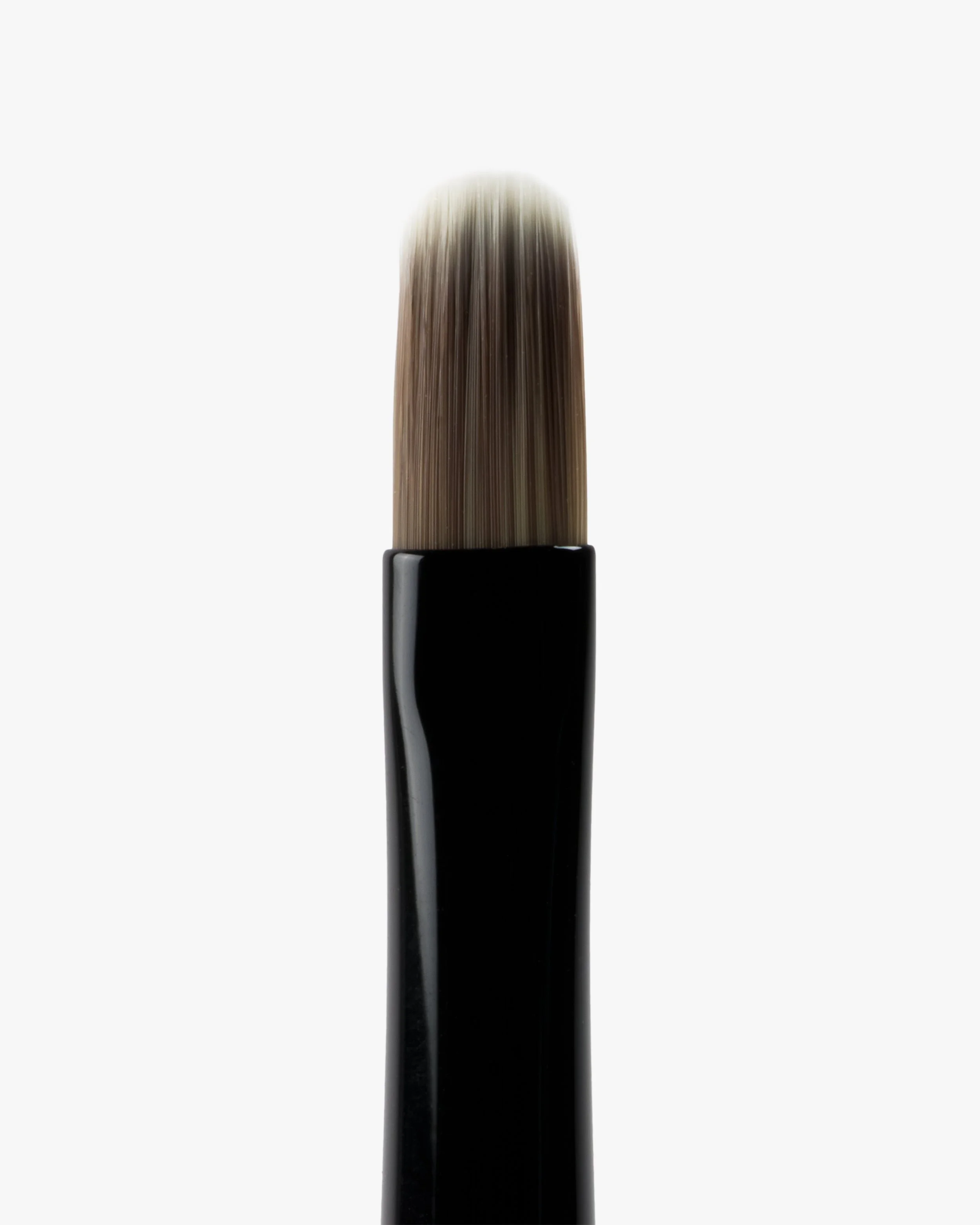 Close-up of a makeup brush with a black handle and soft bristles, isolated on a white background.