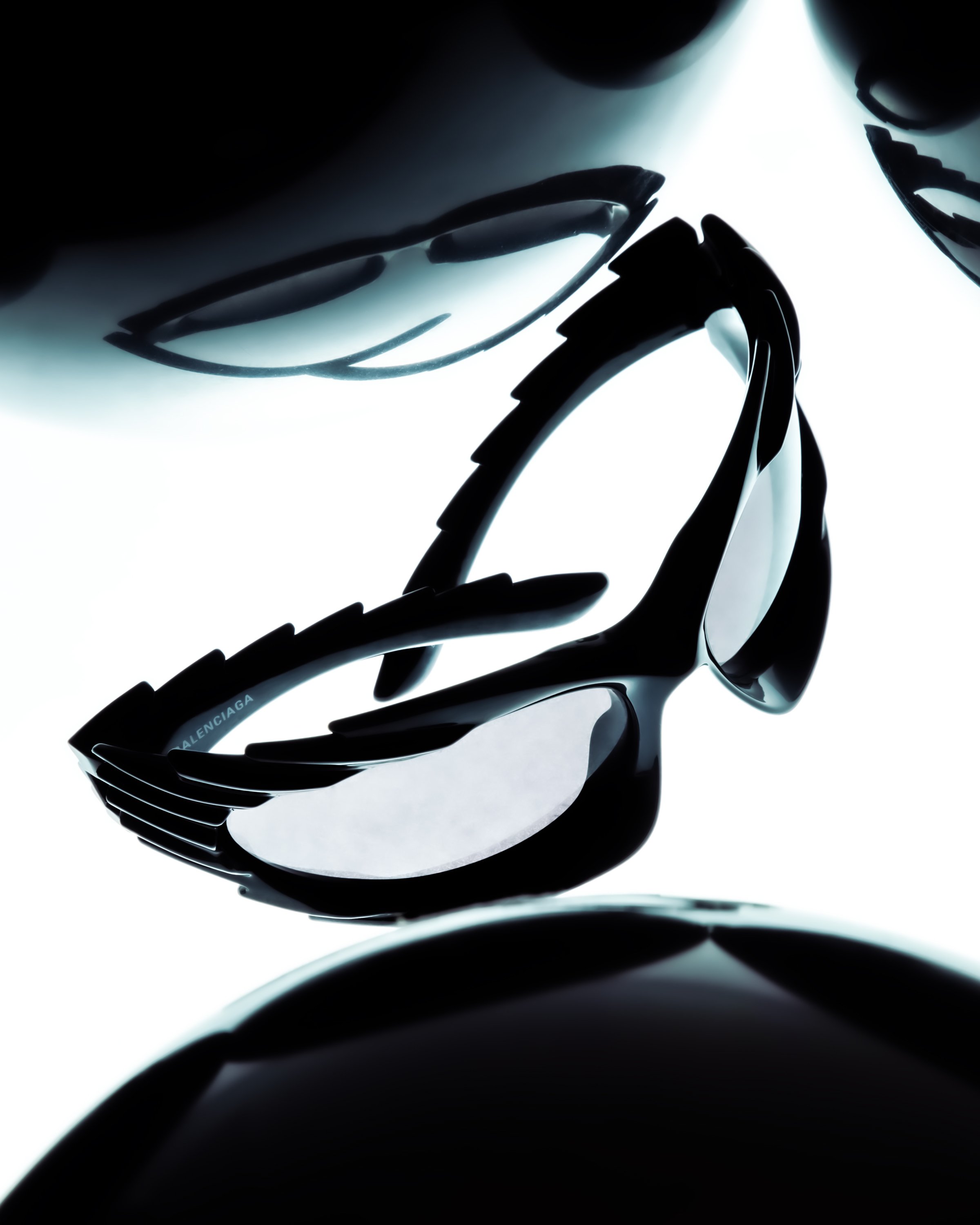 Black high-heeled sunglasses with a white background.